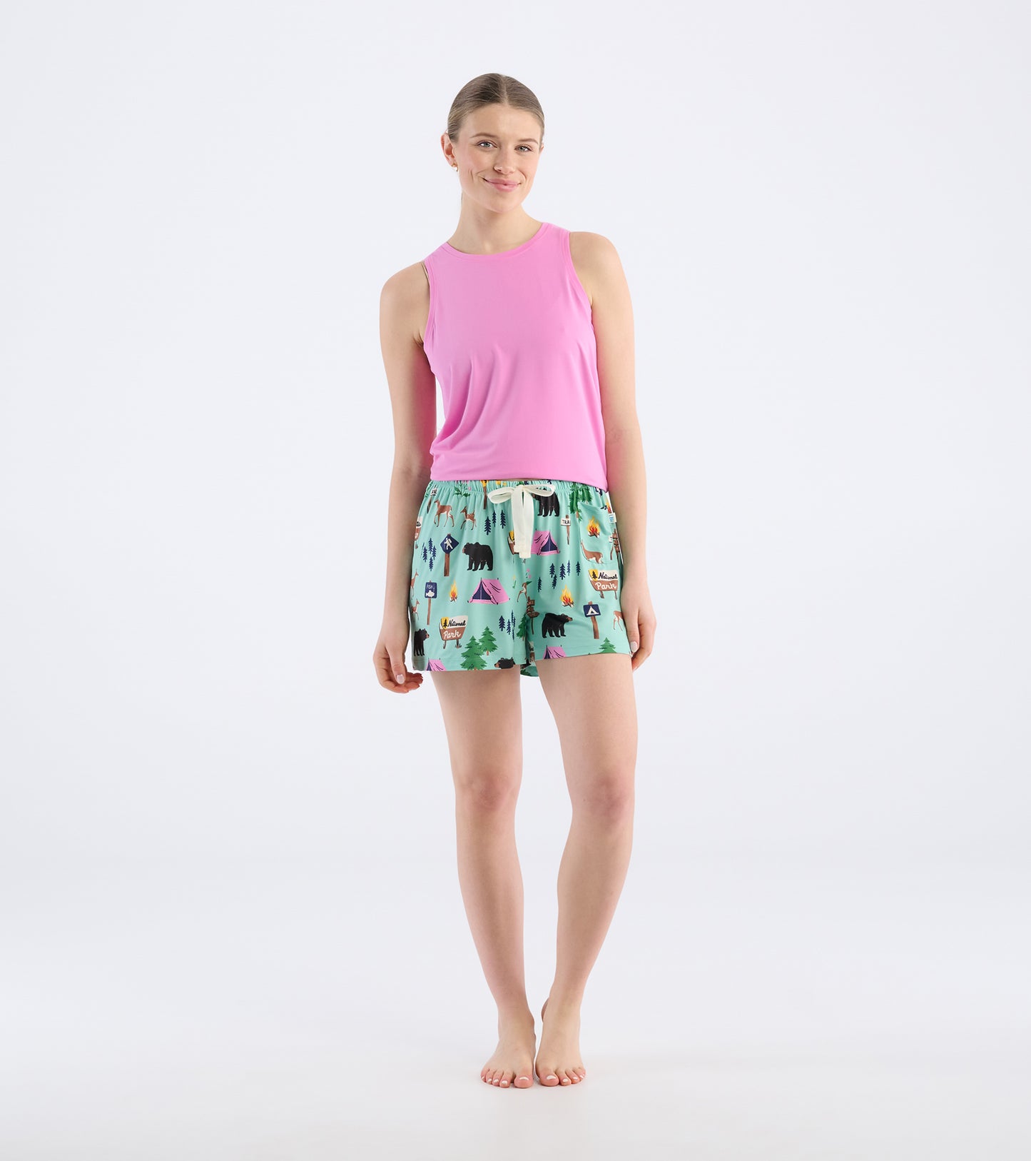 Light pink tank top paired with colorful pajama shorts featuring camping and wildlife patterns. Ideal for casual wear.