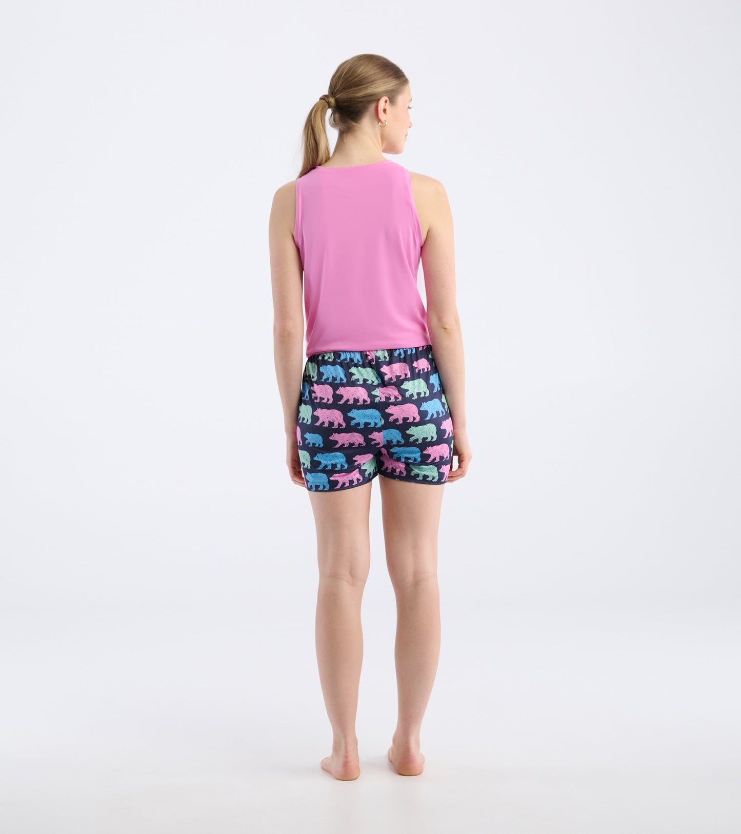 Back view of pajama shorts featuring colorful bear patterns on a dark background, paired with a pink tank top.