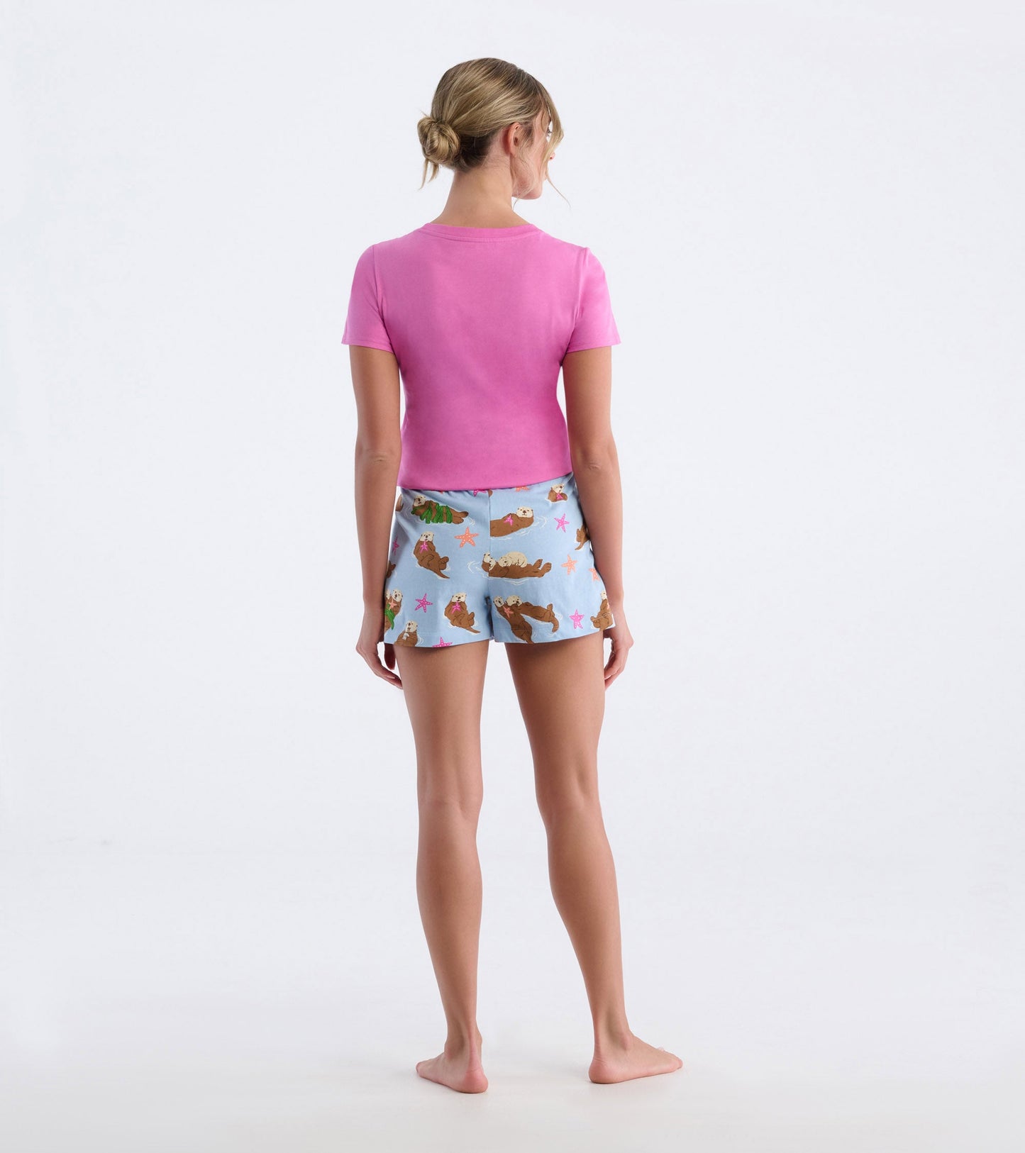 Light blue cotton pajama shorts featuring a playful otter and starfish pattern, paired with a pink short-sleeve top.