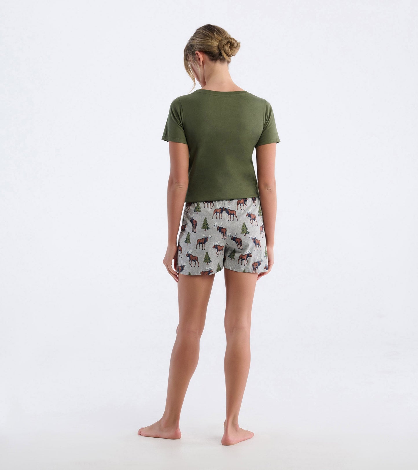 Cotton pajama shorts featuring a moose and tree pattern, shown from the back with a green top.