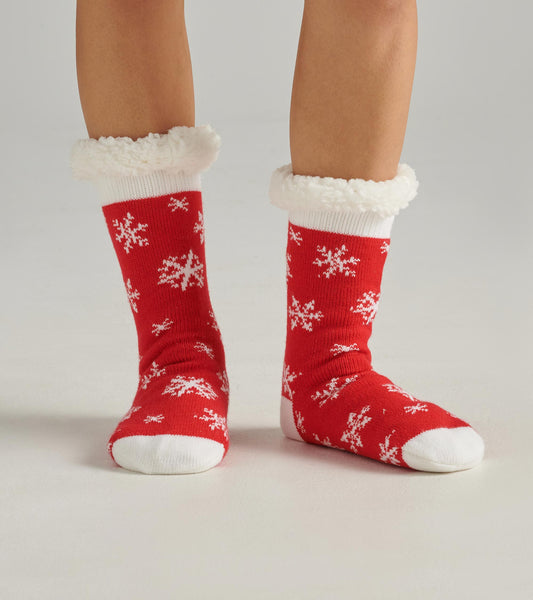 Red cabin socks with white snowflake pattern and fluffy white cuffs, designed for warmth and comfort.