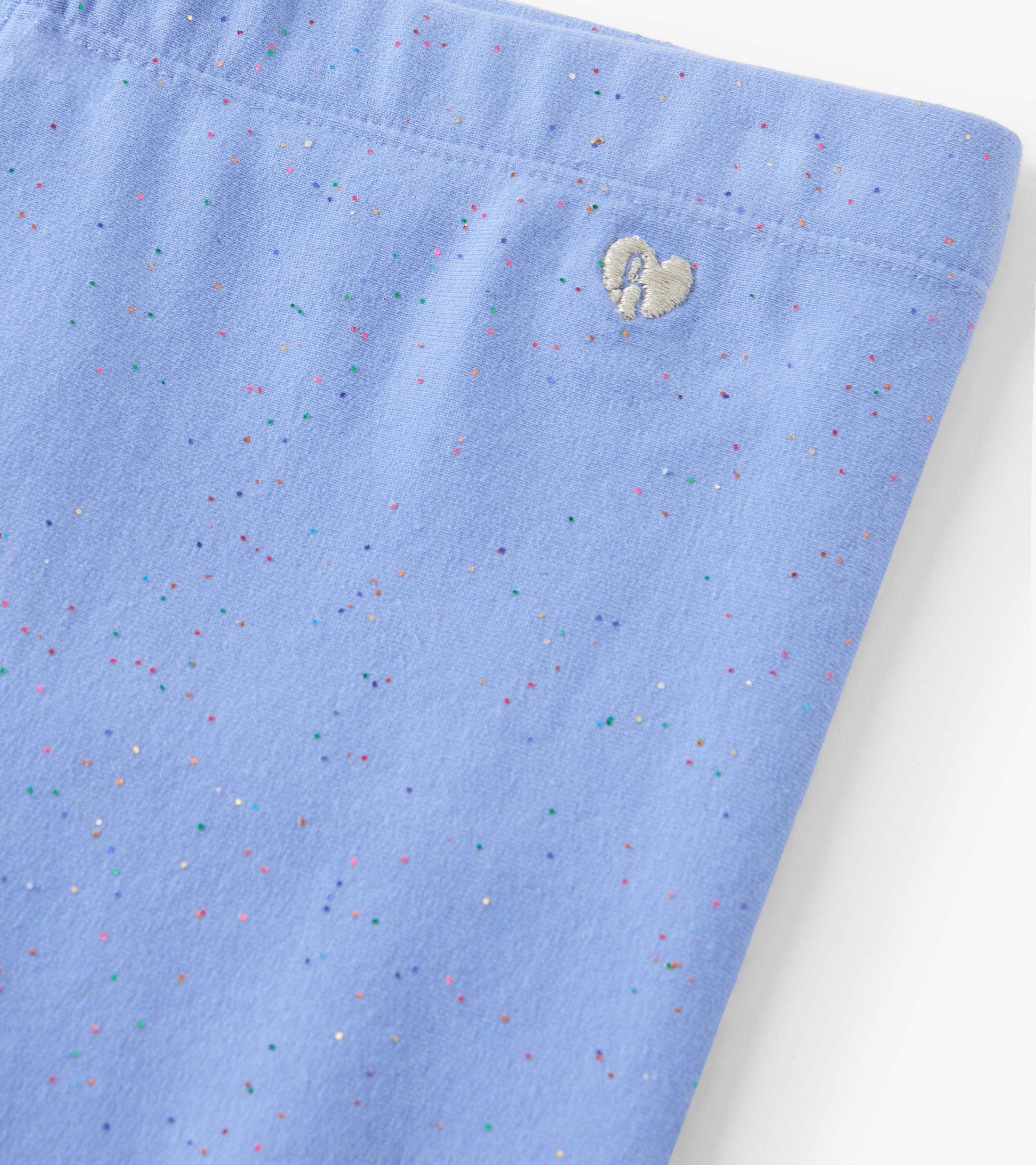 Cornflower blue leggings with a soft texture and colorful speckles, featuring a small embroidered heart detail.