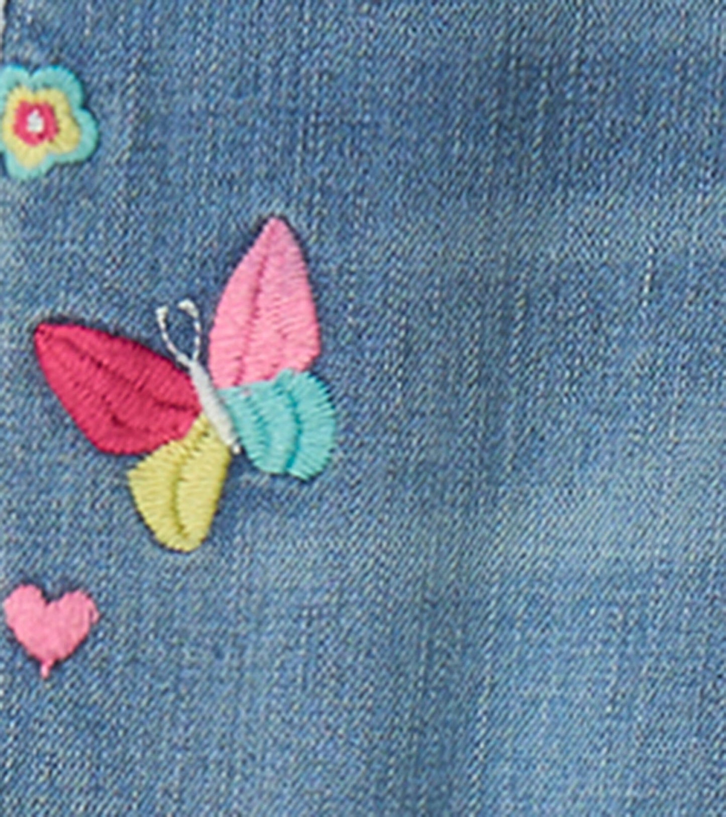 Light blue stretch jeans featuring colorful embroidered butterfly and flower patches.