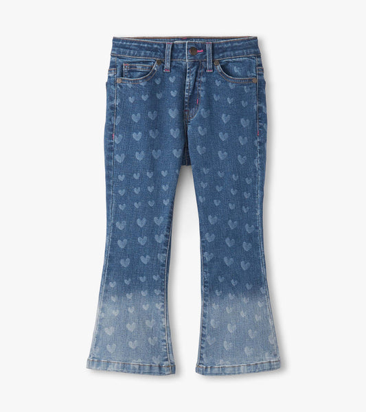 Flared leg denim jeans featuring a heart pattern, in a medium blue wash with lighter fading at the hem.