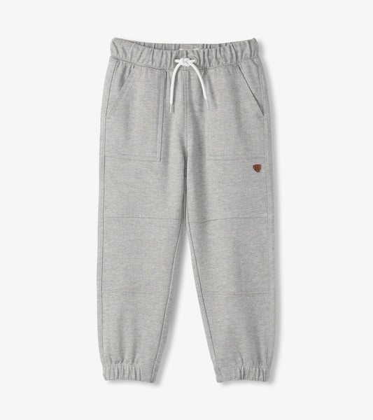 Grey cozy pants with an elastic waistband, drawstring, and side pockets, featuring a tapered leg design.