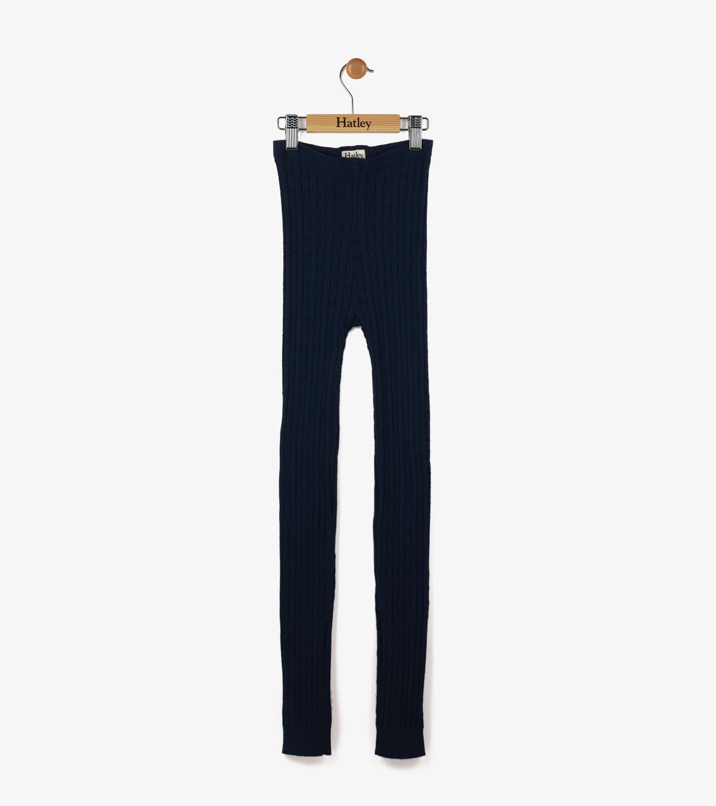 Navy cable knit tights with a ribbed texture, designed for girls, hanging on a wooden hanger.