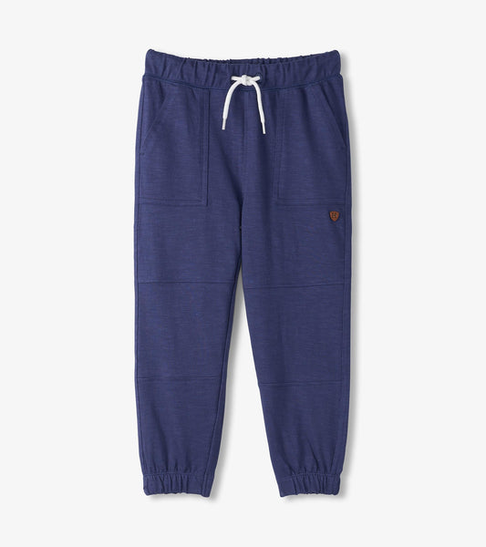 Navy cozy pants with an elastic waistband, drawstring, and side pockets, featuring a relaxed fit and cuffed ankles.