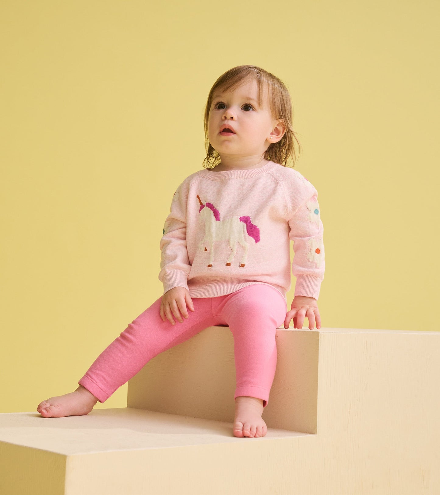 Pink cozy leggings, soft material, fitted style, perfect for toddlers, paired with a light pink sweater.