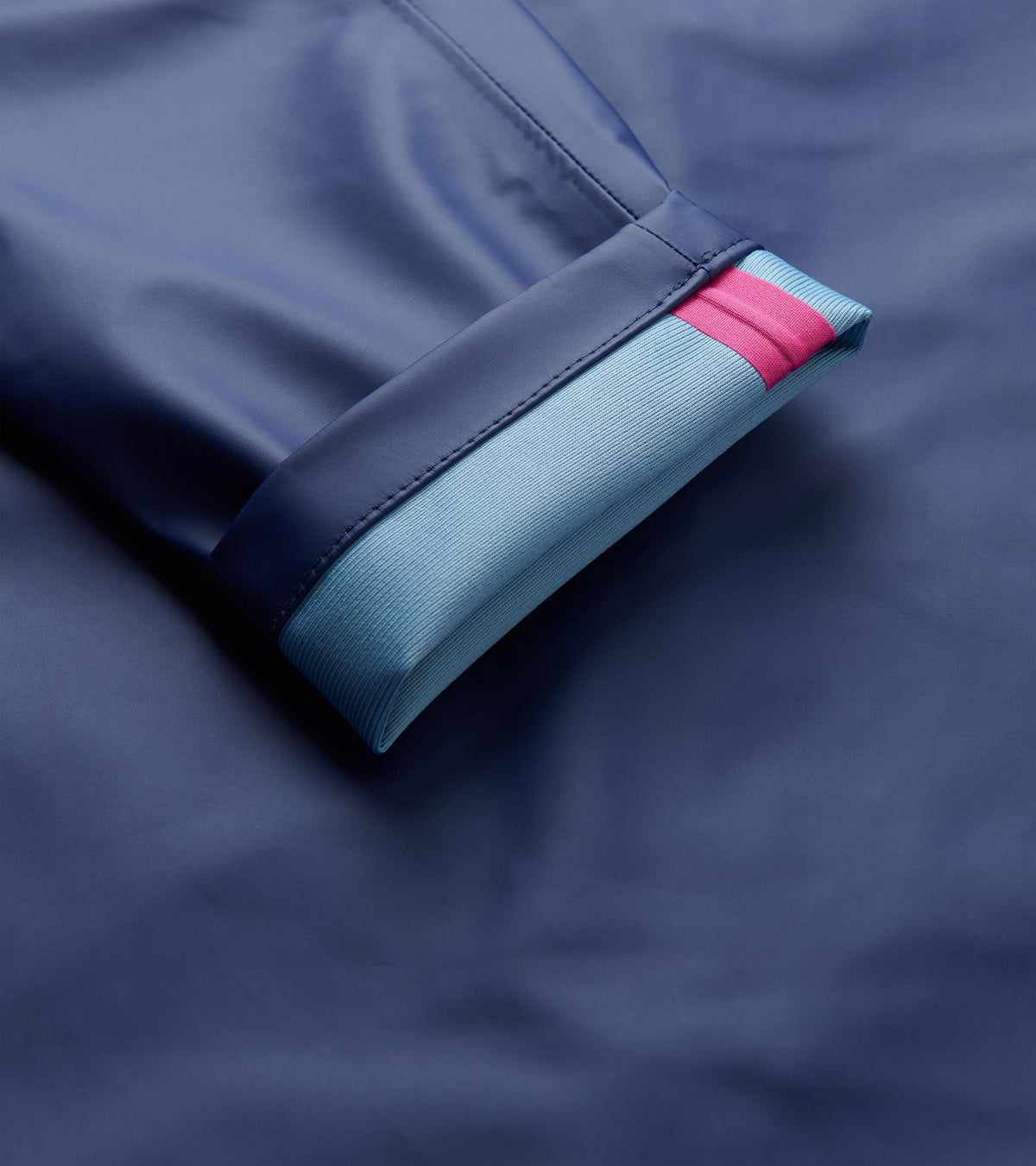 Close-up of patriot blue rain jacket cuff with light blue ribbed lining and a pink stripe.