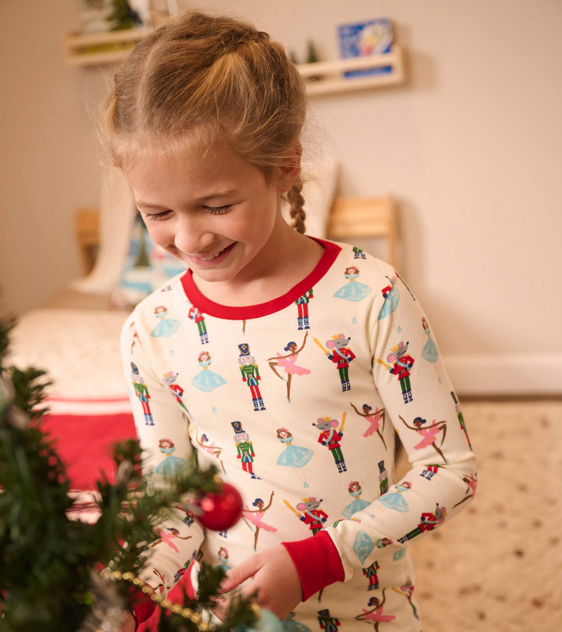 Organic cotton pajama set featuring a festive nutcracker and ballet dancer print, with red trim and long sleeves.