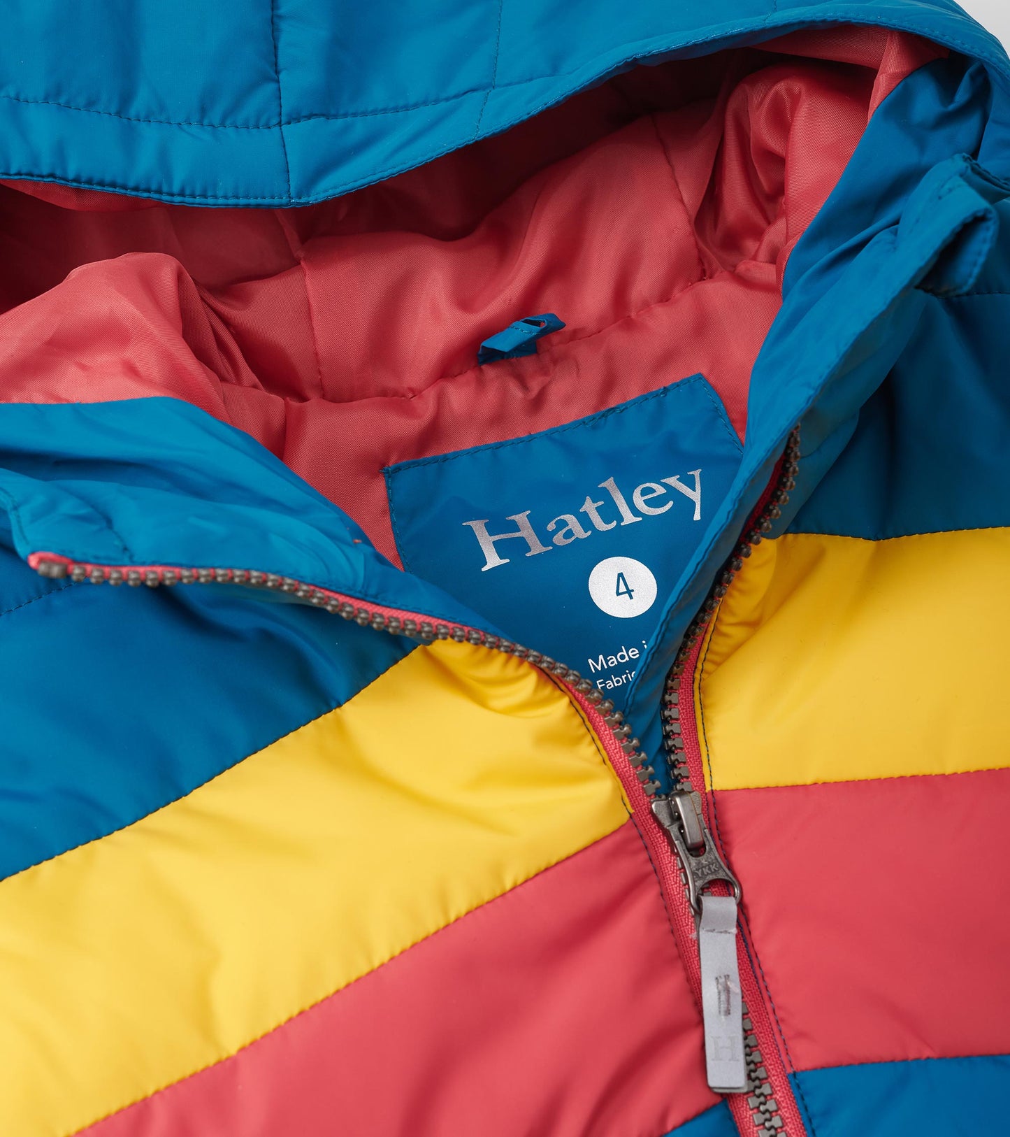 Colour block puffer jacket featuring blue, yellow, and red stripes with a zip closure and hood. Lined interior visible.