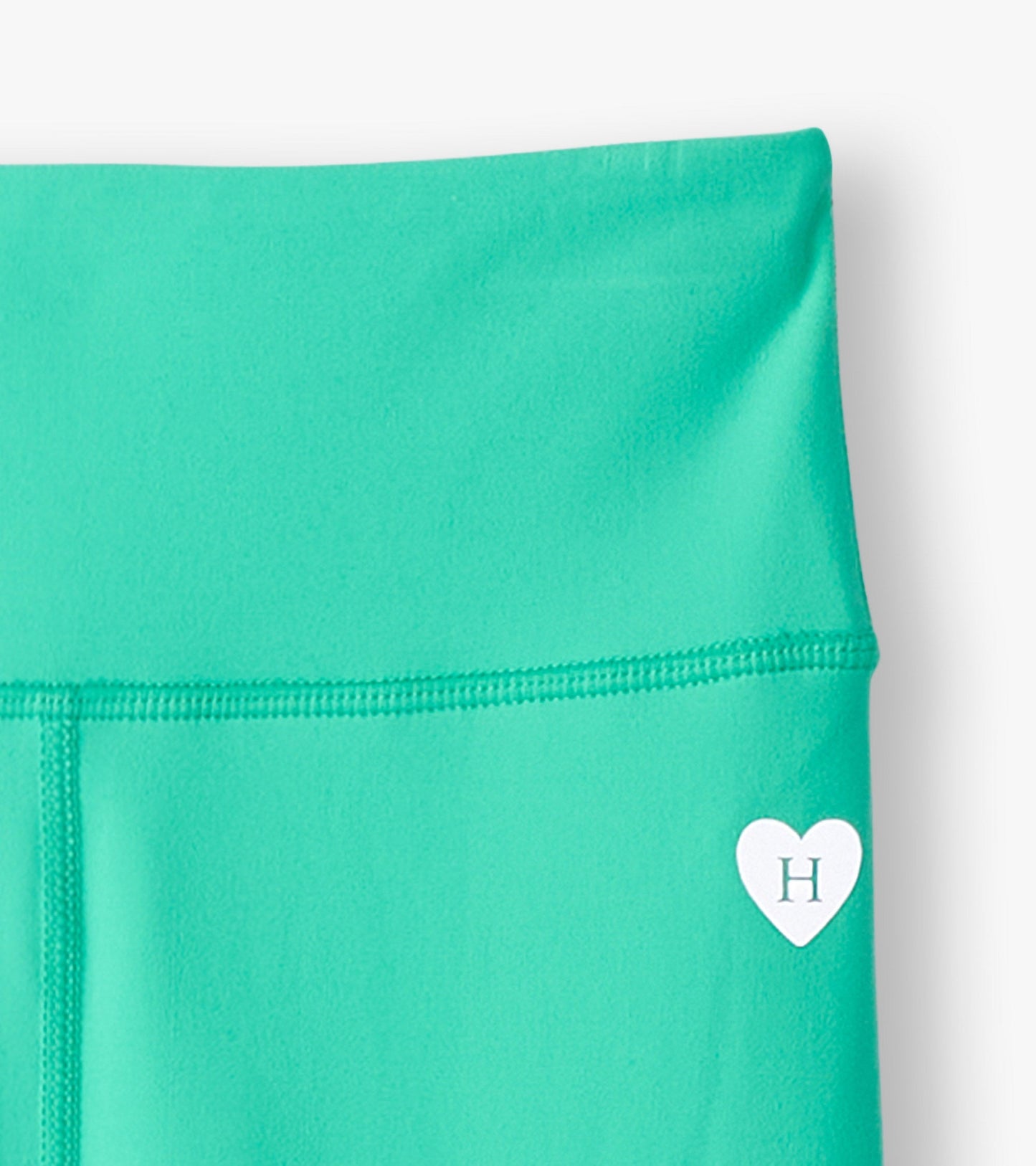 Aqua green active leggings with a smooth texture and a small heart logo on the waistband.