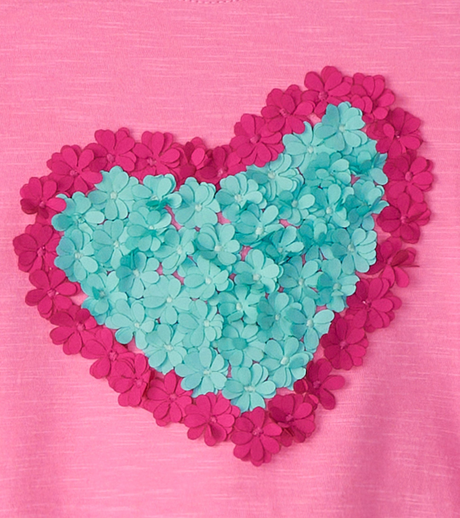 Pink long sleeve t-shirt featuring a heart design made of teal and magenta flower appliqués.