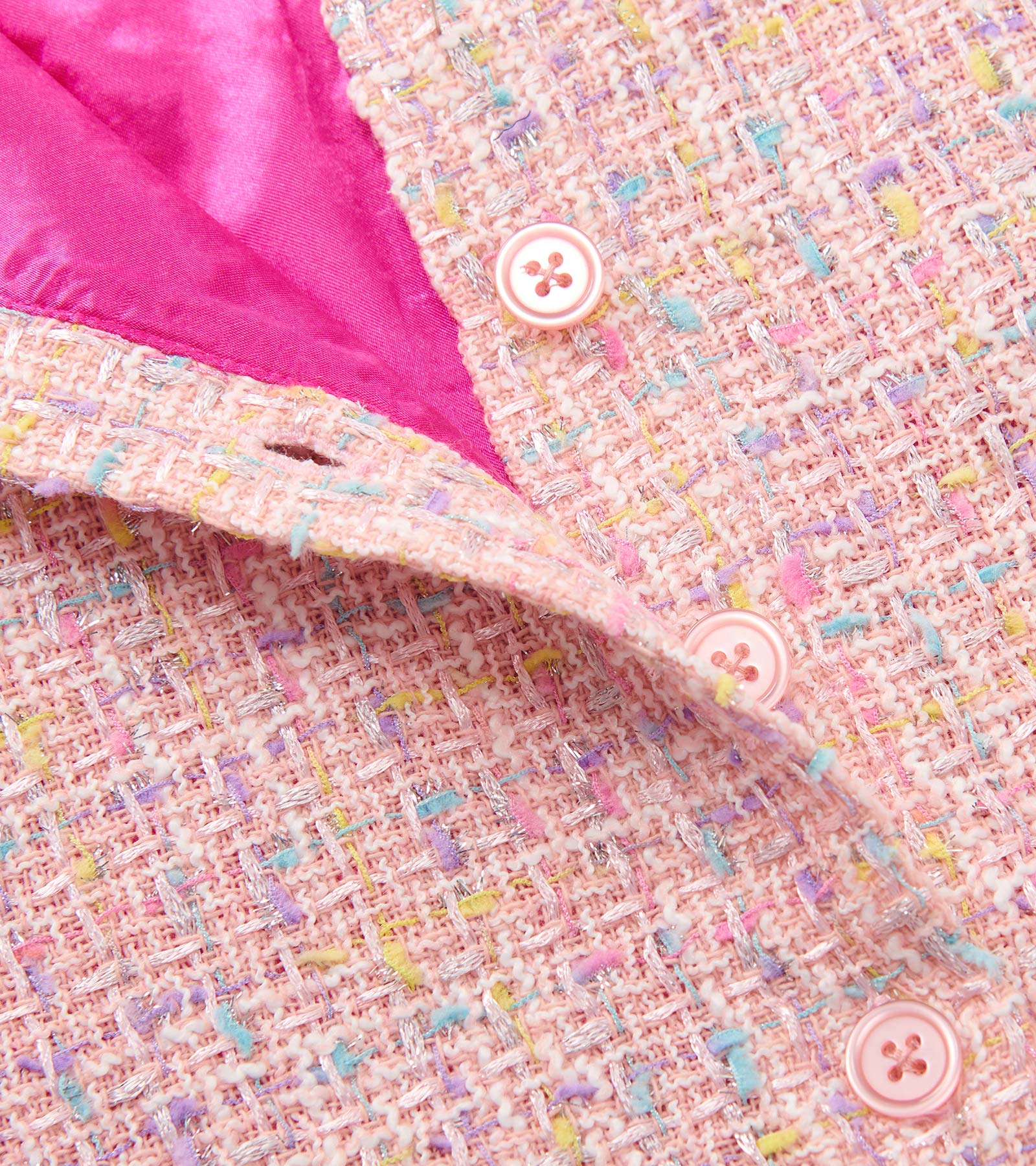 Aurora pink tweed dress with faux fur trim, featuring colorful specks and pink satin lining, showcasing button detail.