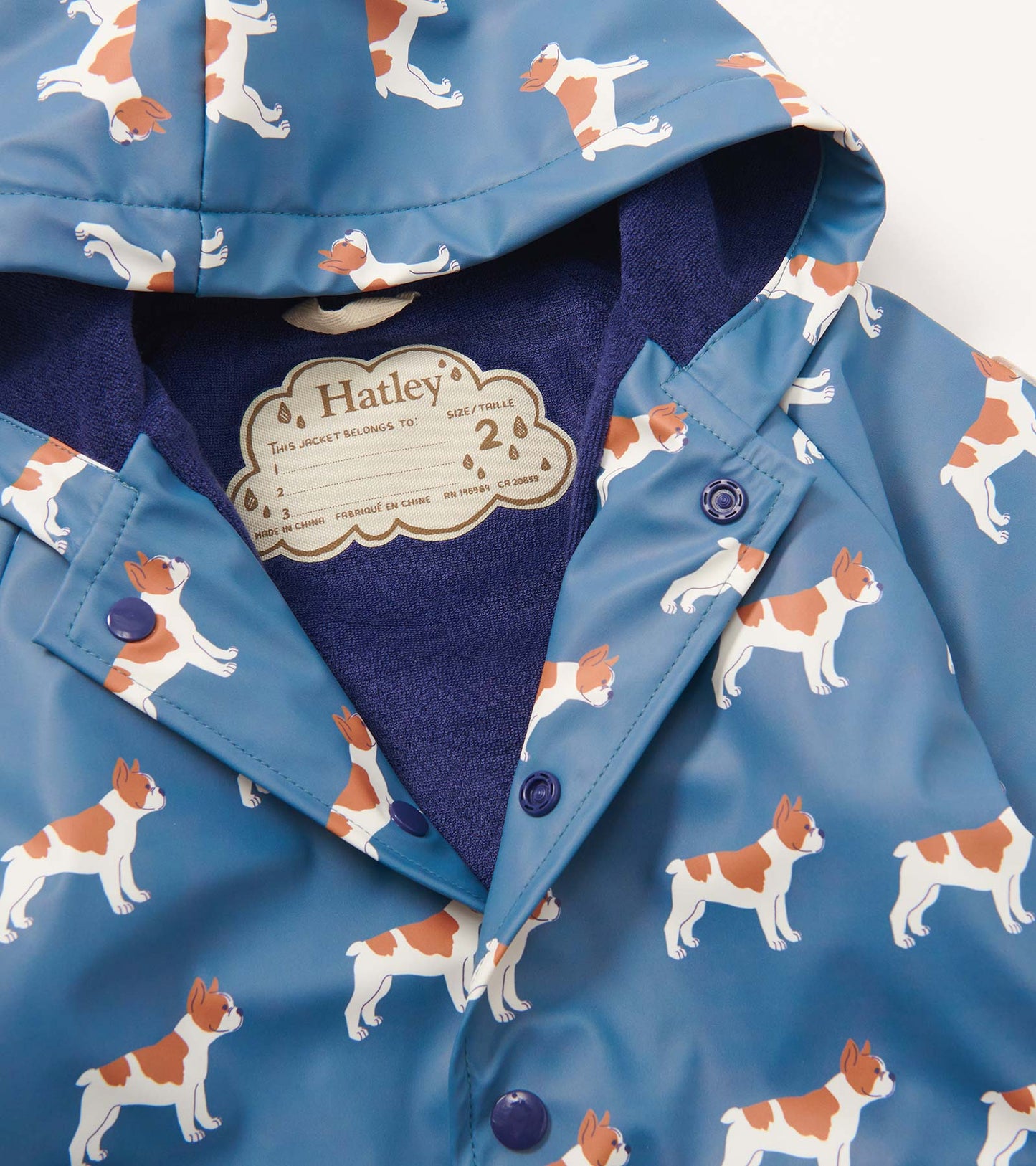 Blue rain jacket featuring a playful French bulldog pattern, with a hood and button-up front. Lined with soft fabric.