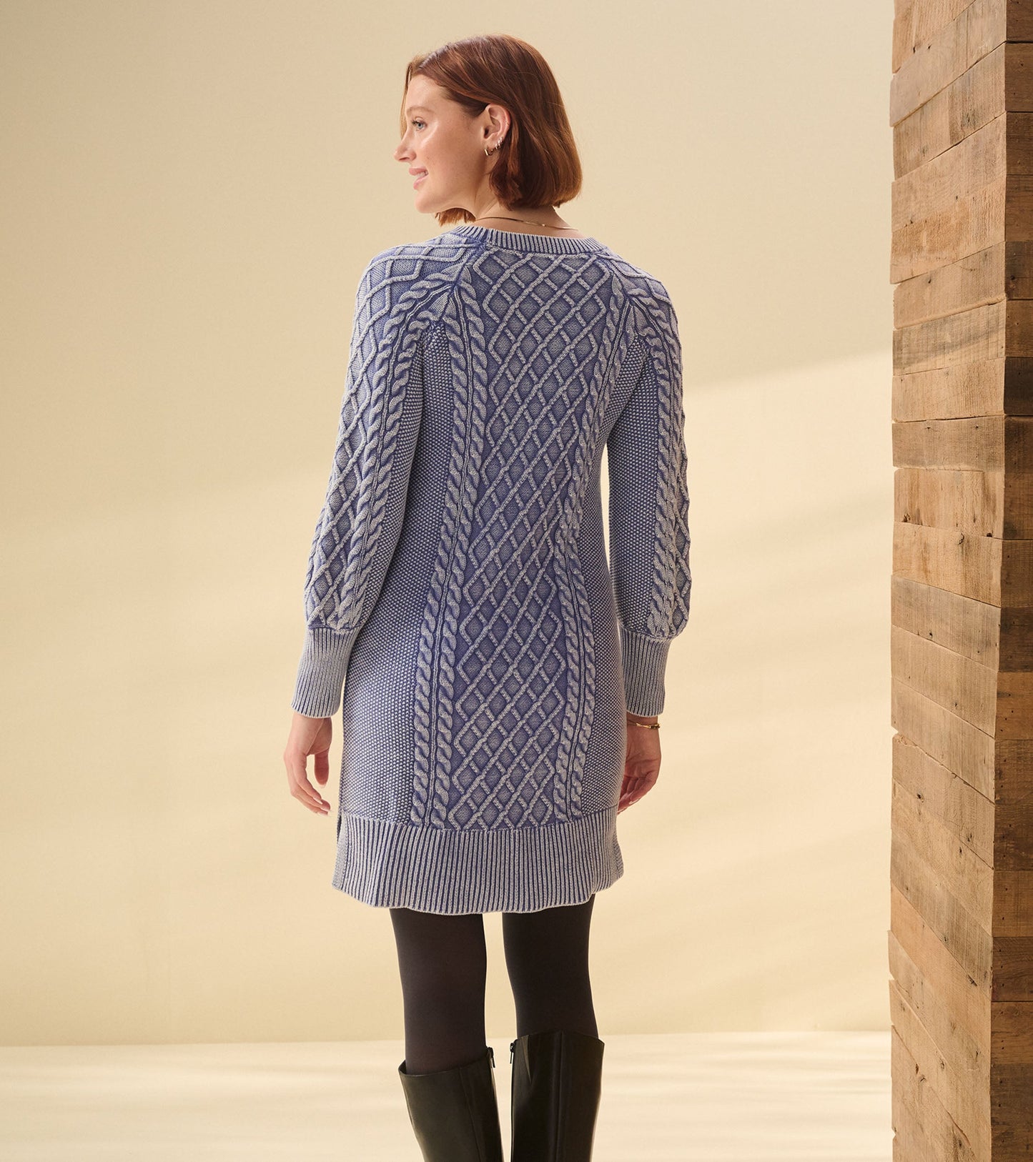 Cable knit dress in bleached denim blue, featuring a fitted silhouette and long sleeves, shown from the back.