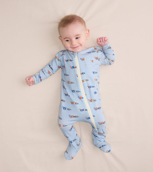Light blue bamboo sleeper with colorful car prints, featuring a front zipper and footed design, suitable for baby boys.