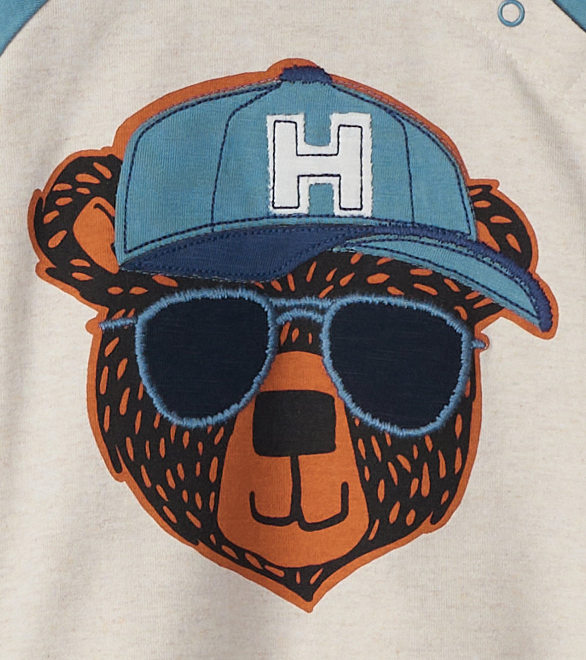 Light beige long sleeve t-shirt featuring a cool bear graphic with sunglasses and a blue cap.