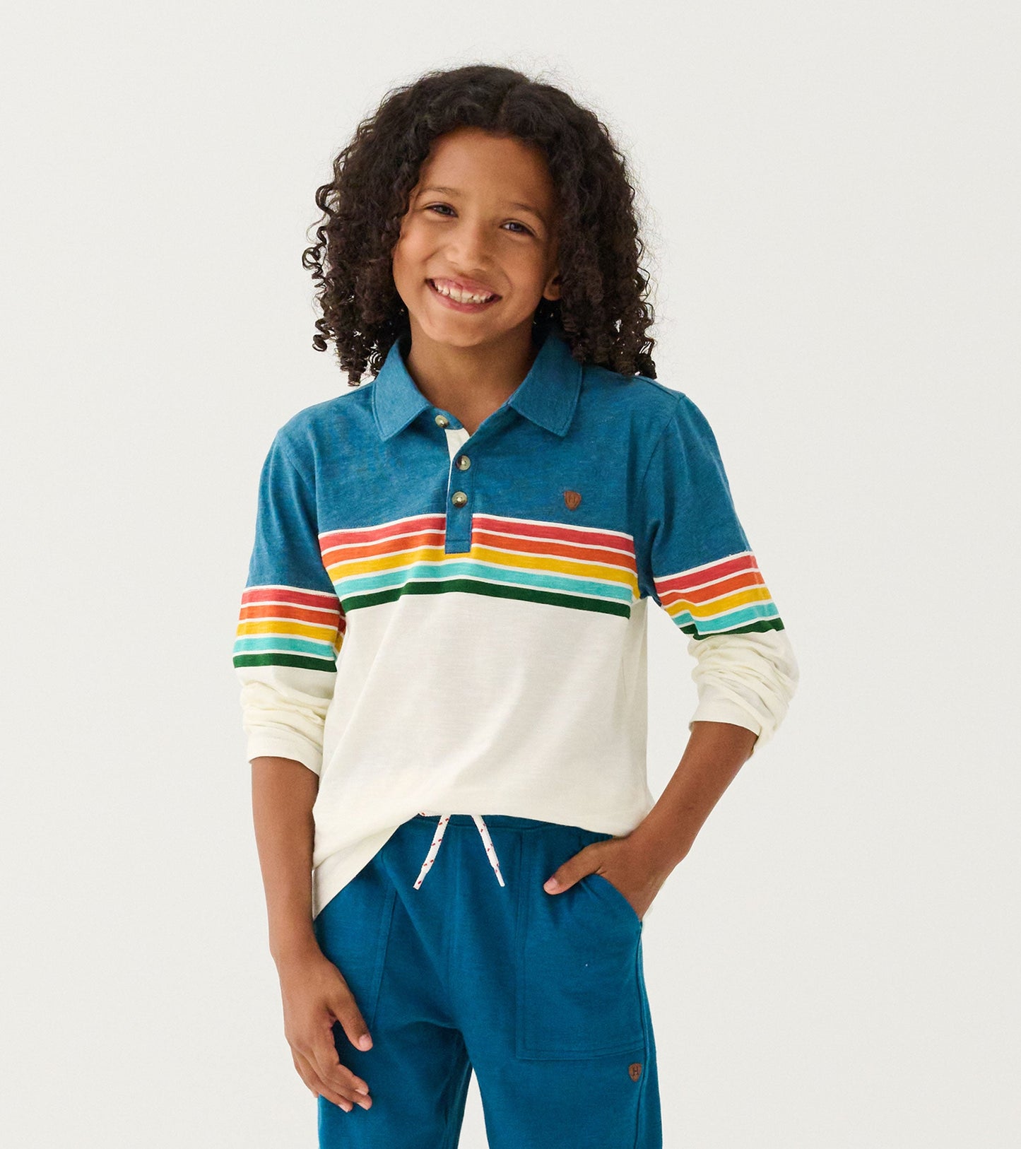 Long sleeve polo featuring a blue top with colorful retro stripes and a cream body, perfect for casual wear.
