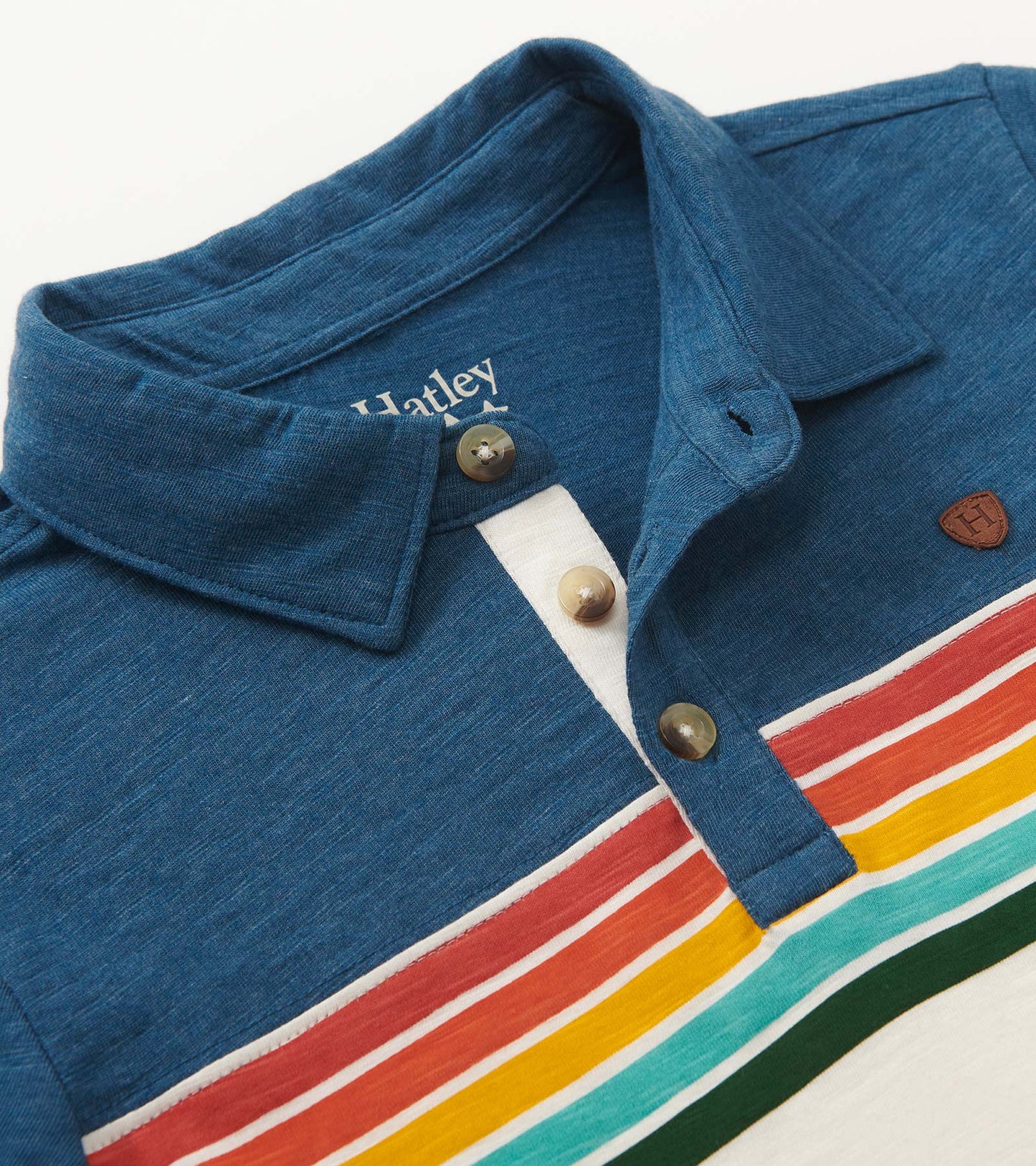 Blue long sleeve polo with retro stripes in red, yellow, and green; features a buttoned collar and soft fabric.