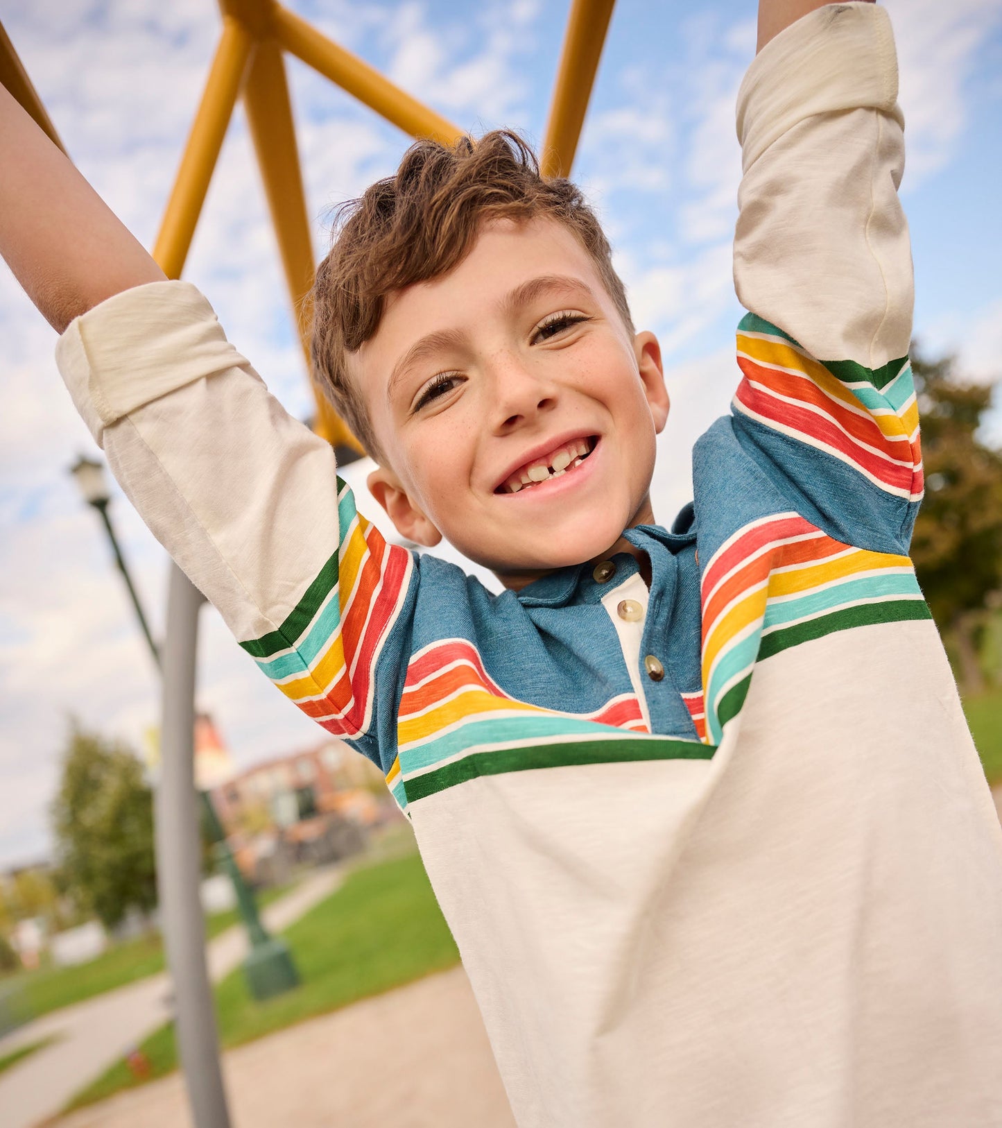 Long sleeve polo featuring retro stripes in blue, red, yellow, and green, with a buttoned collar and a relaxed fit.