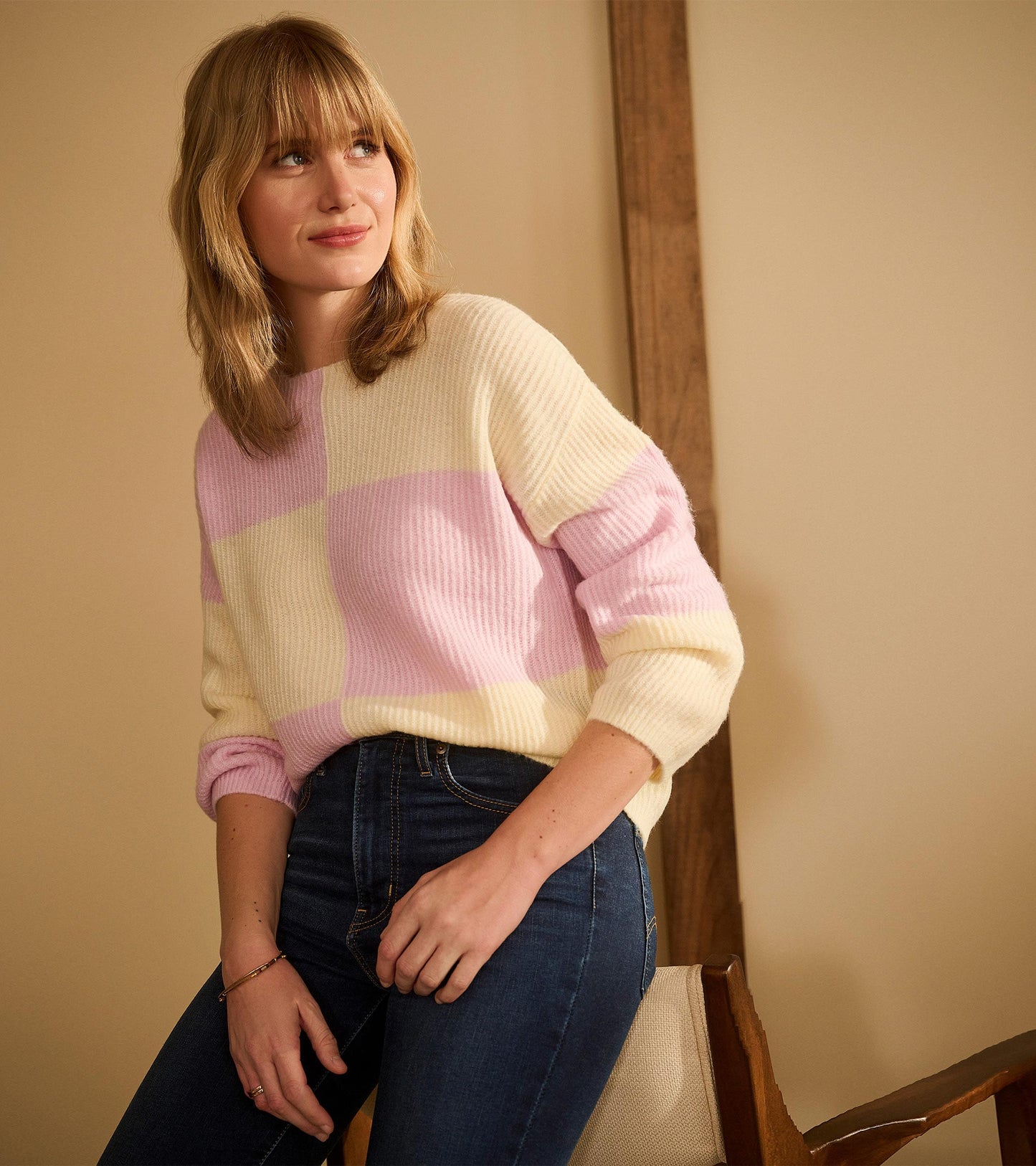 Pink and cream block-patterned sweater with ribbed texture, featuring a relaxed fit and long sleeves.
