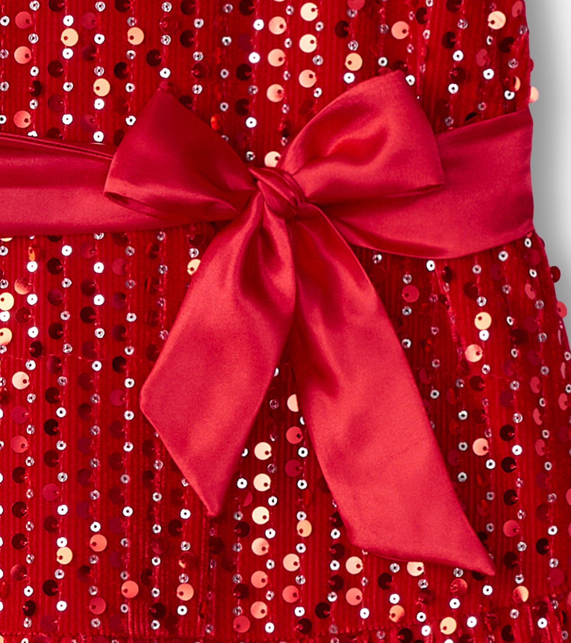 Red velvet dress adorned with sequins, featuring a satin bow at the waist.