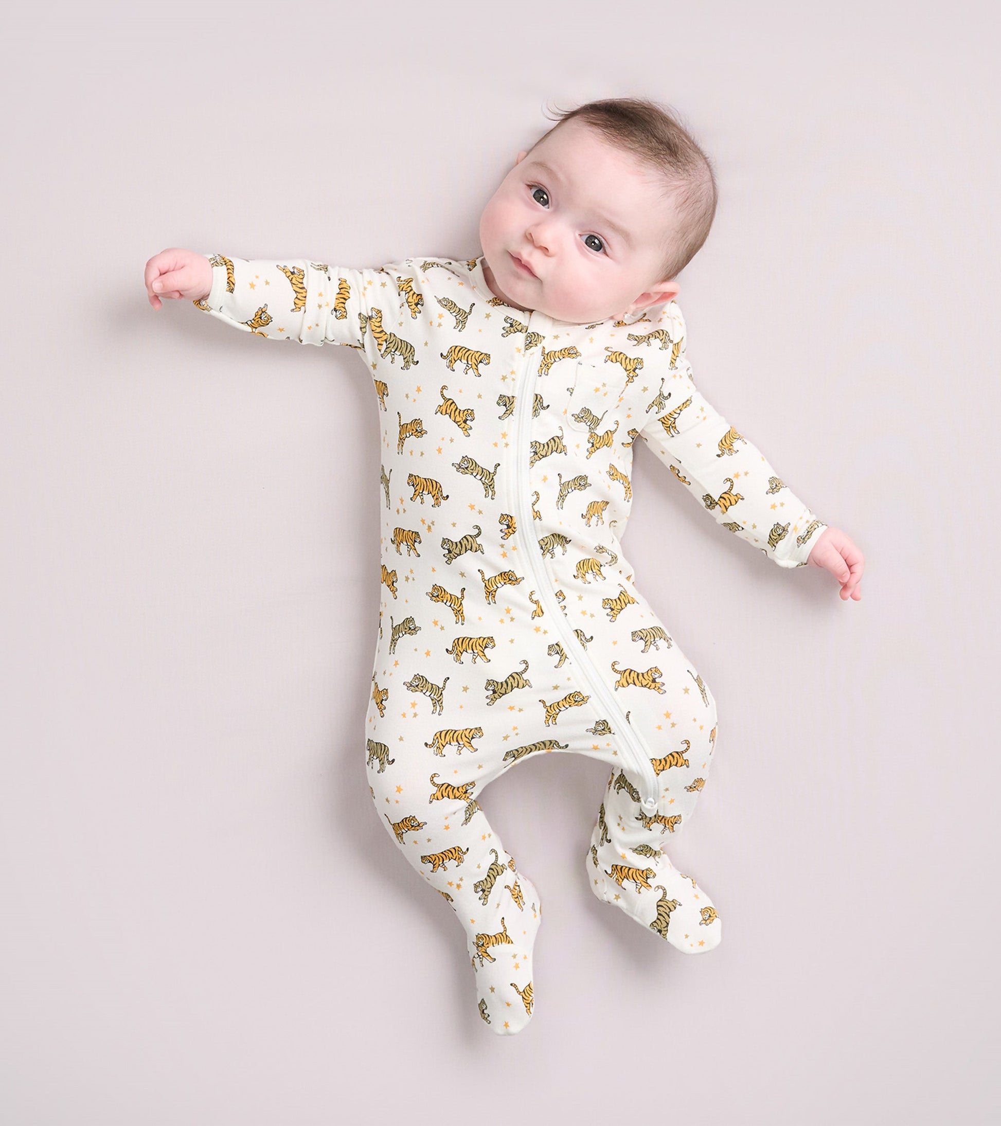 Bamboo sleeper for baby boys featuring a cream background with playful tiger and celestial patterns. Zipper closure.