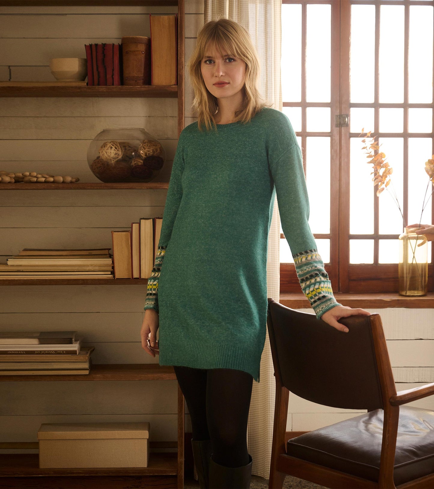 Forest green sweater dress with patterned sleeves, featuring a relaxed fit and ribbed hem, styled with black leggings.