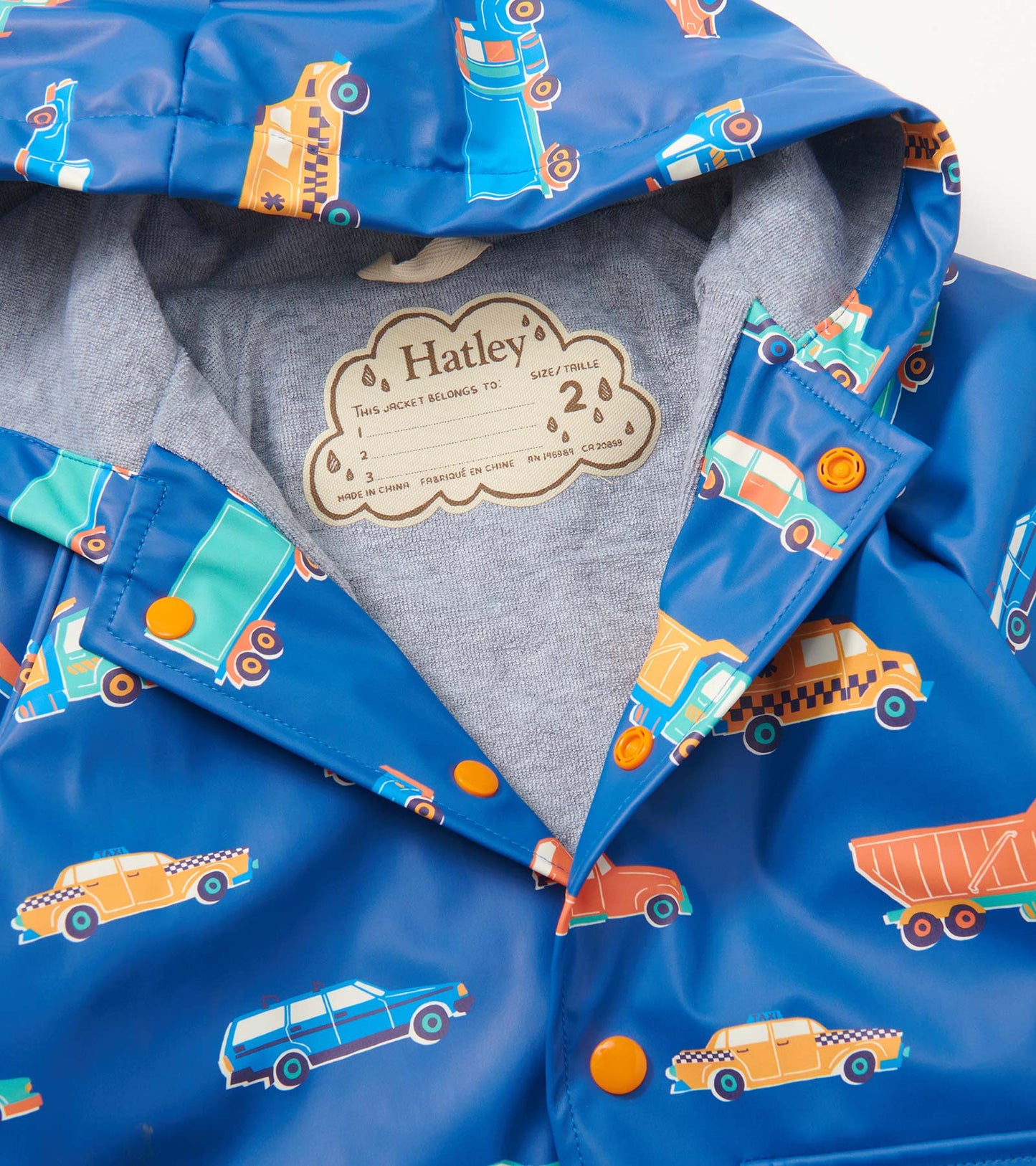 Blue rain jacket featuring colorful driving car patterns, with a hood and orange snap buttons.