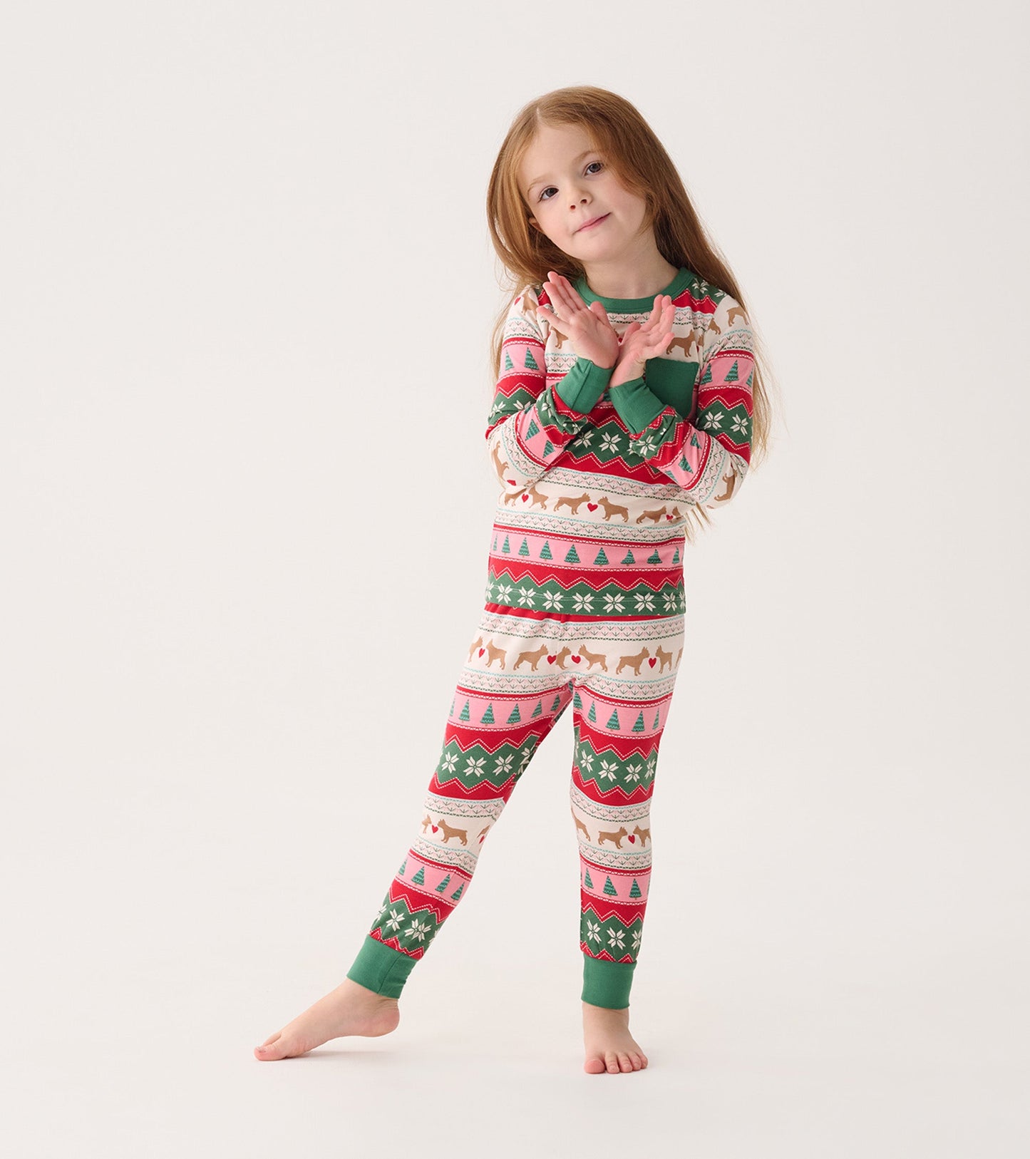 Bamboo pajama set for girls featuring a festive Fair Isle pattern with puppies, trees, and snowflakes in pink and green.