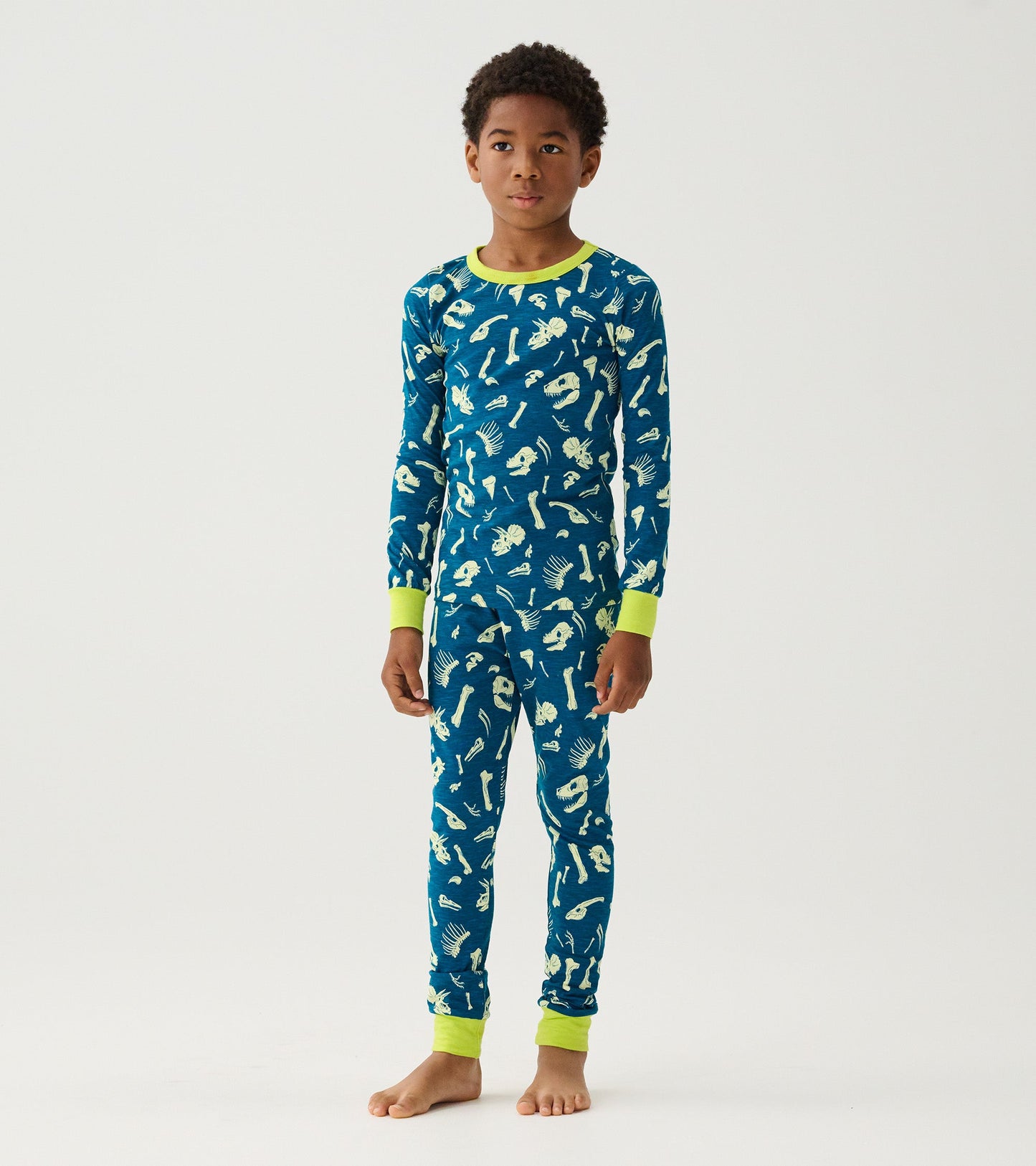 Blue pajama set featuring dinosaur fossil patterns, with bright green cuffs and neckline, designed for boys.