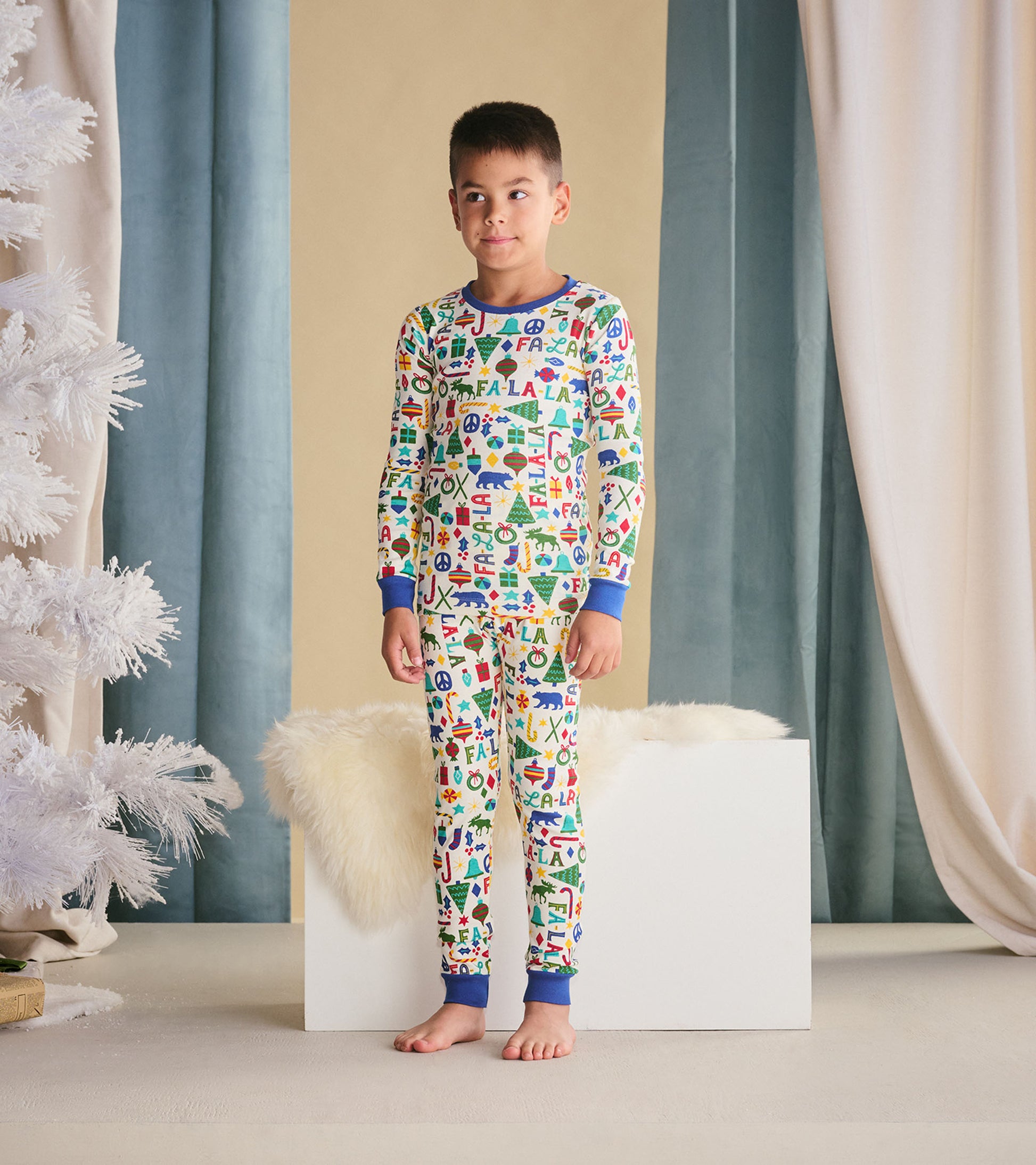 Boys' blue pajama set featuring colorful holiday-themed patterns, long sleeves, and matching pants.