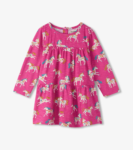 Pink gathered tiered dress featuring a whimsical unicorn print, long sleeves, and a round neckline.
