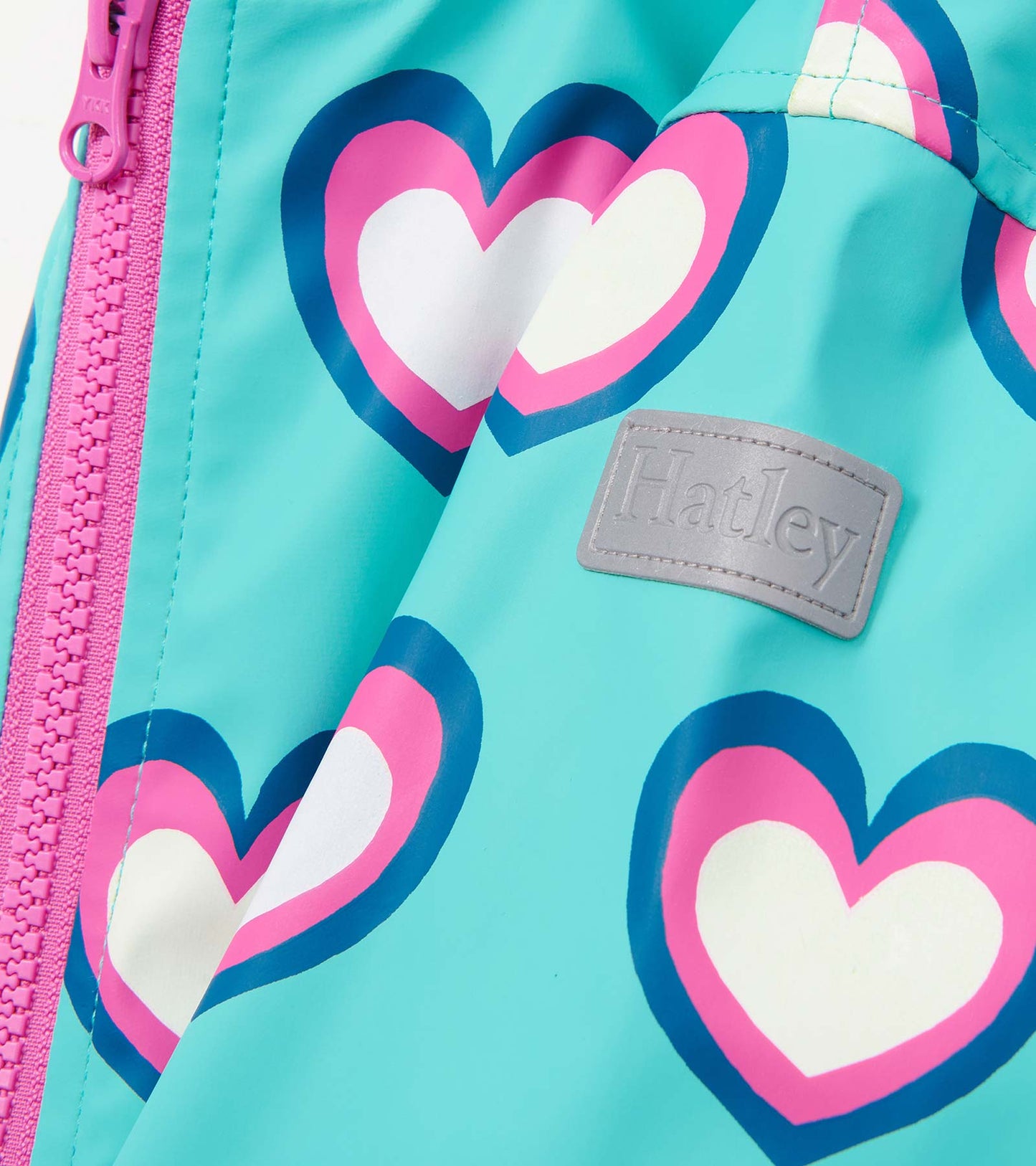 Turquoise rain jacket featuring colorful heart patterns and a pink zipper, designed for girls.