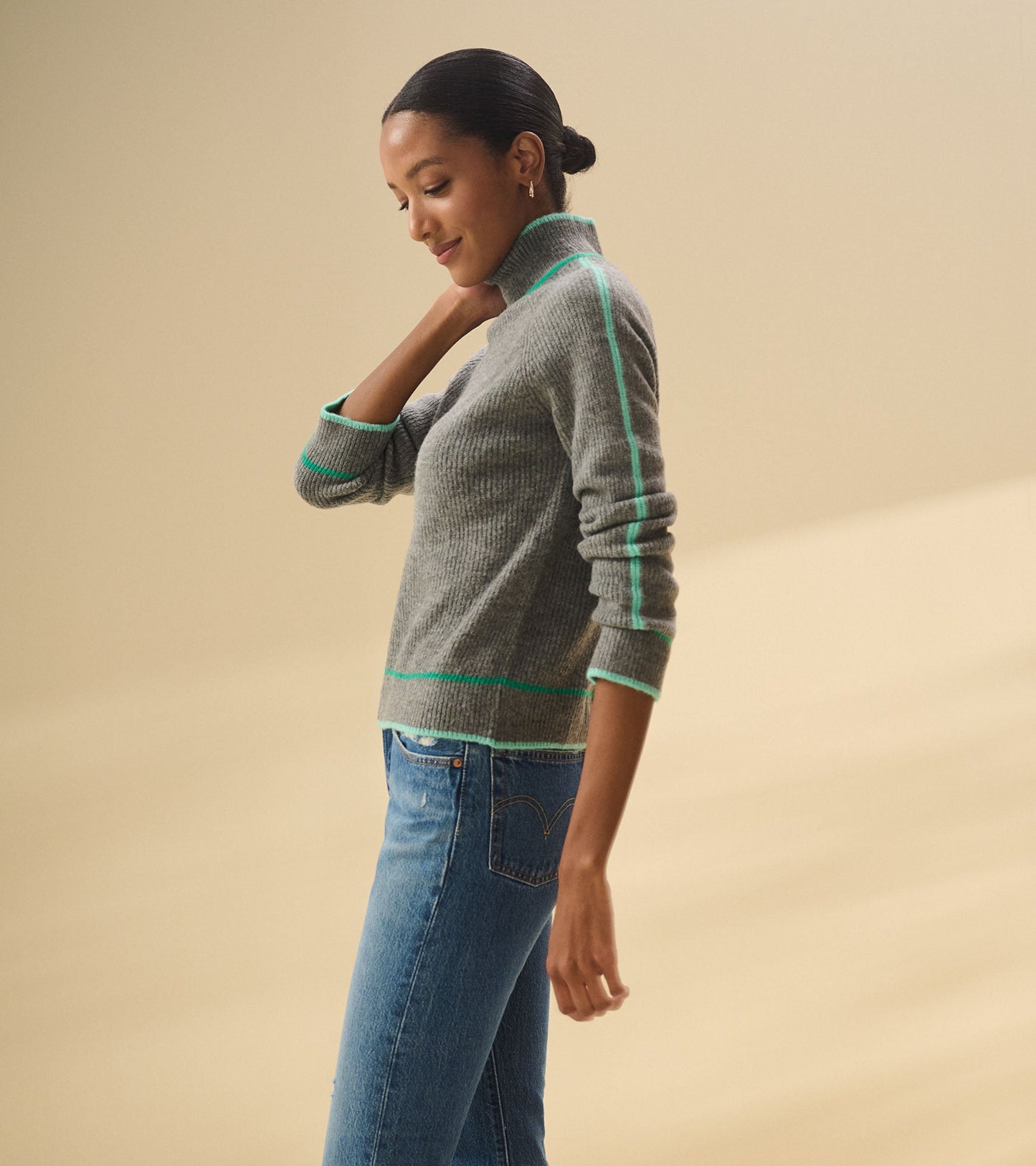 Charcoal heather pullover with a mock neck and green trim, styled with blue jeans, shown from the side.