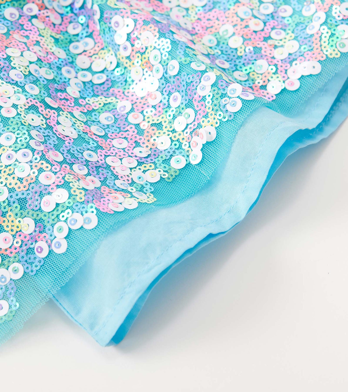 Light blue tulle skirt adorned with multicolored sequins, featuring a soft lining and a flowing design.