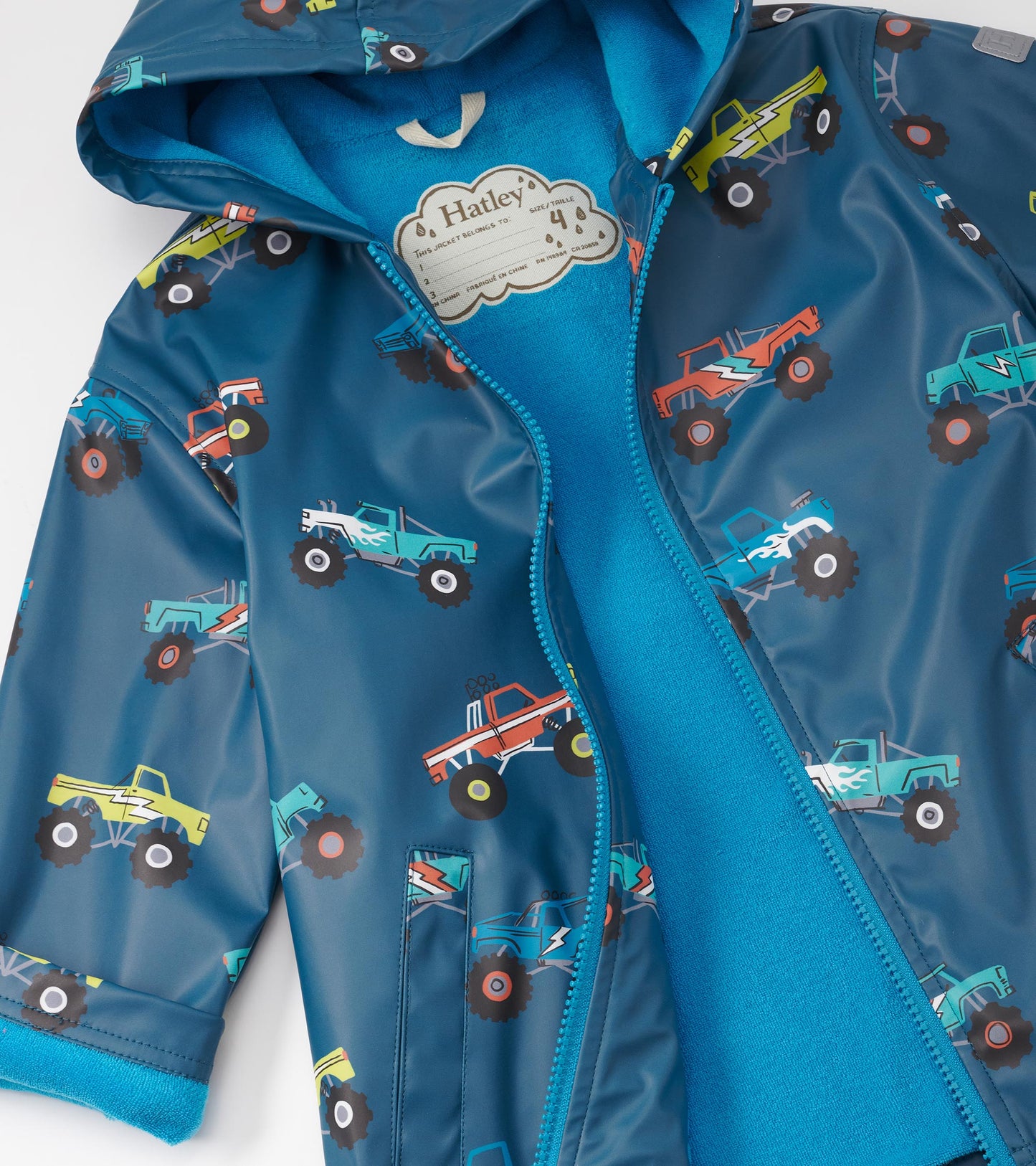 Blue zip-up rain jacket featuring colorful monster truck patterns, with a soft blue interior lining.