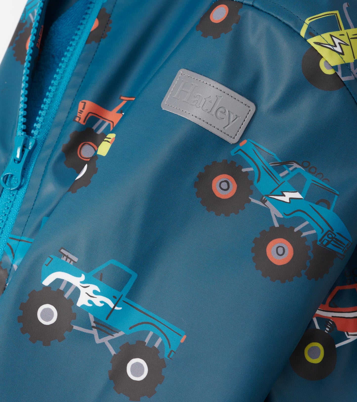 Teal zip-up rain jacket featuring colorful monster truck patterns, ideal for boys.