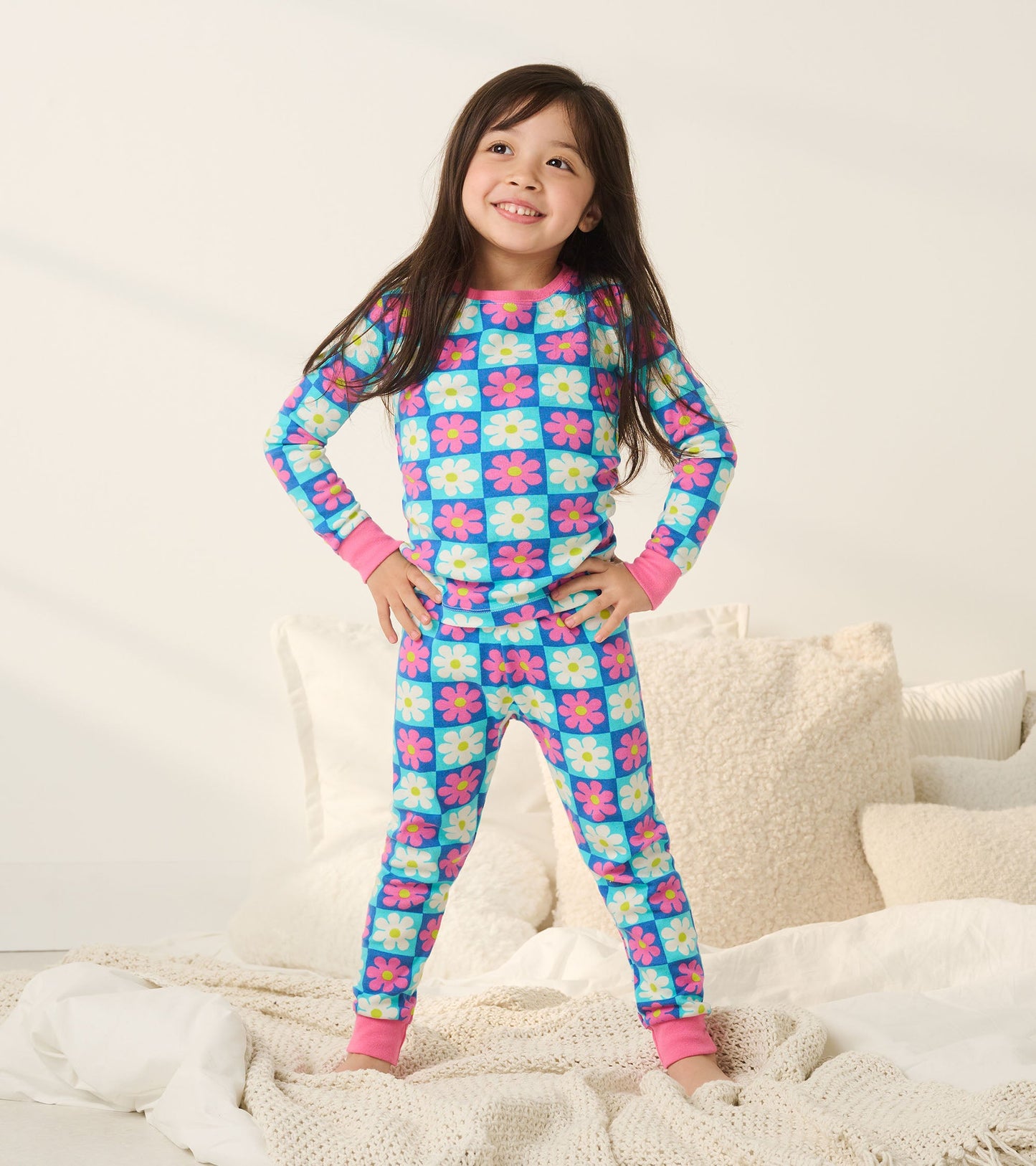 Colorful checkered pajama set with daisies in blue, pink, and white, featuring long sleeves and matching pants.