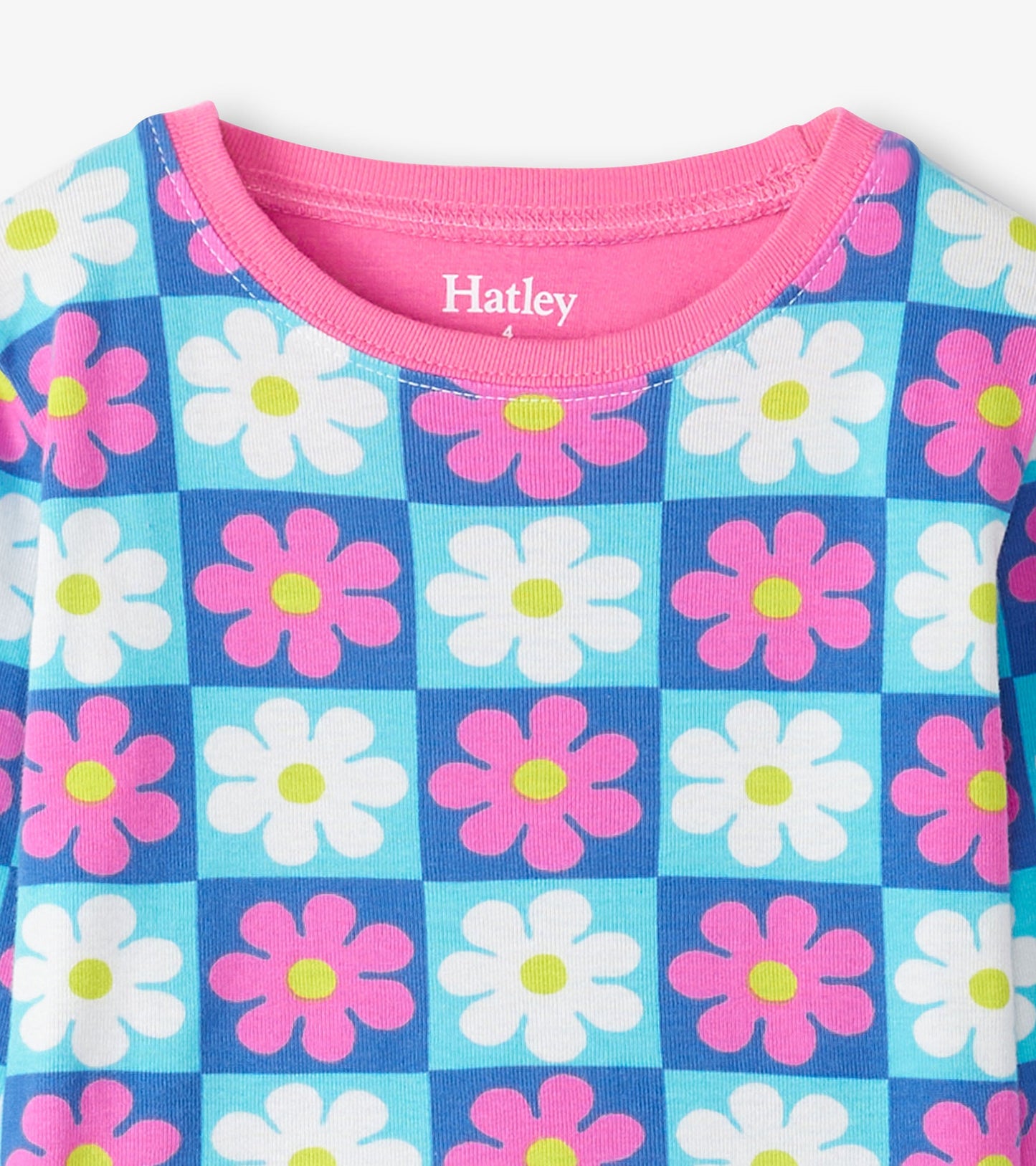 Colorful checkered pajama set featuring pink and white daisies on a blue background, made from organic cotton.