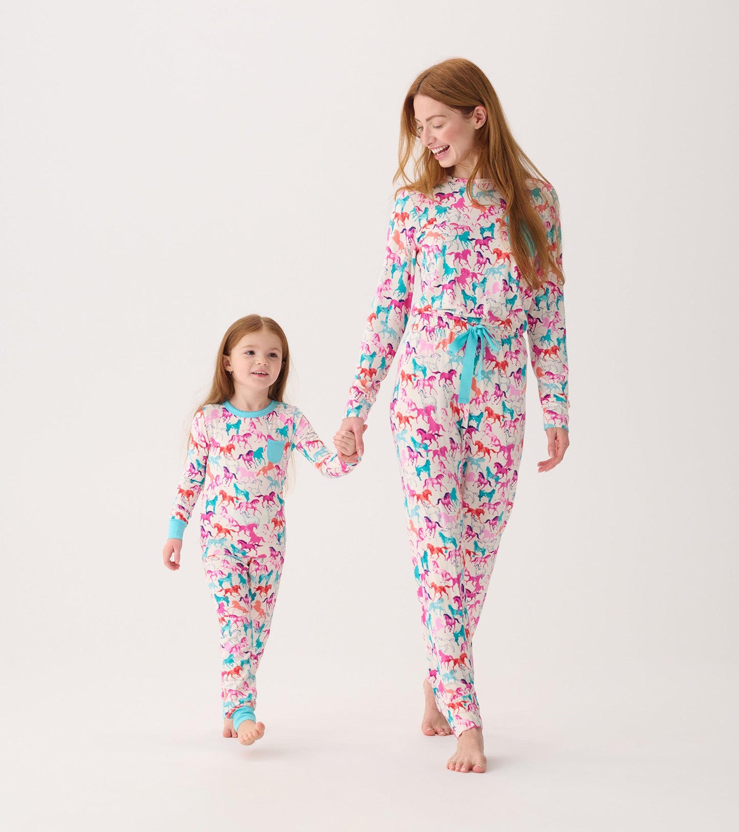Colorful bamboo pajama set featuring playful horse patterns, worn by a mother and daughter, holding hands.