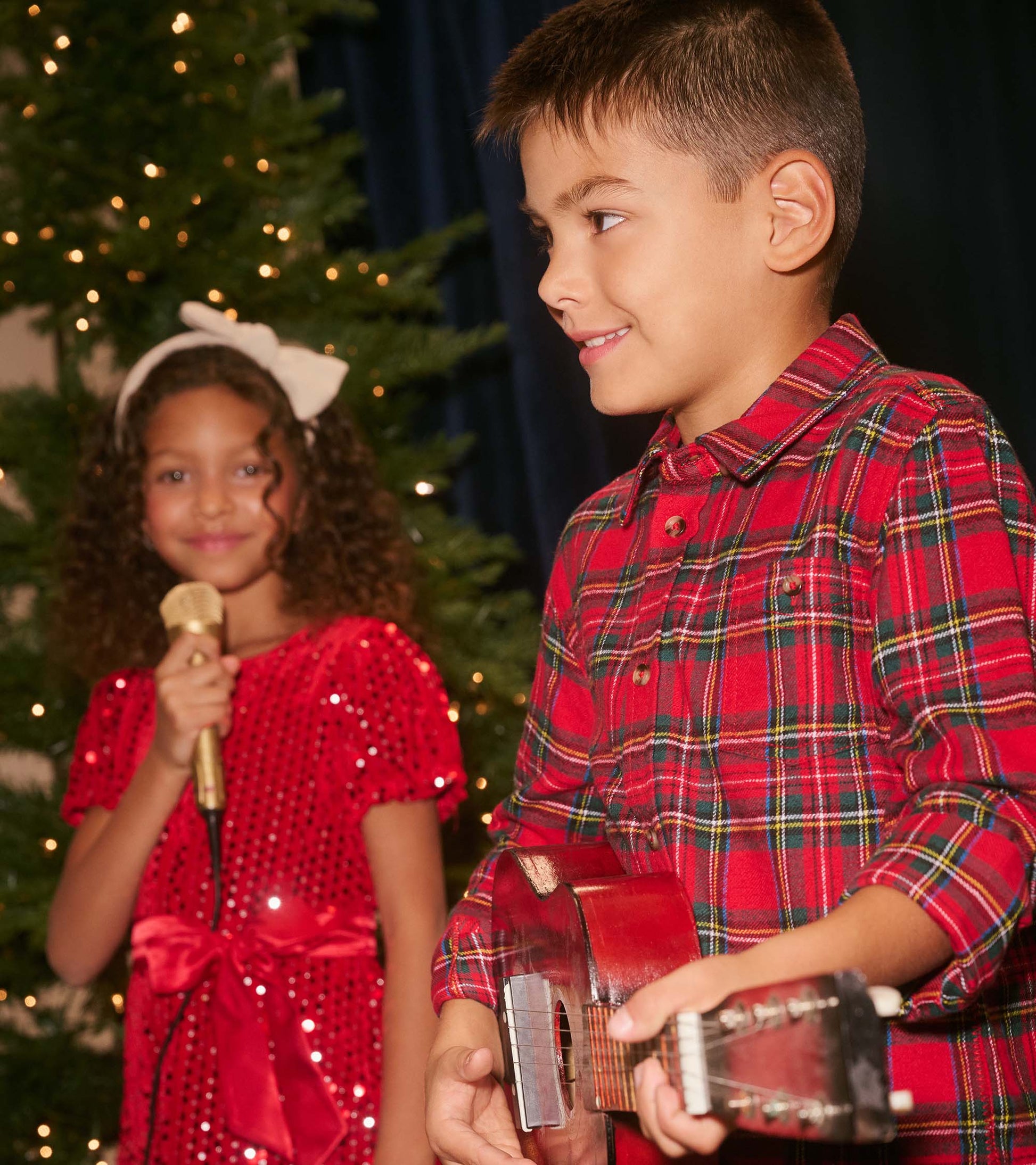 Boys' red plaid button-down shirt with a classic collar, worn while playing a ukulele.