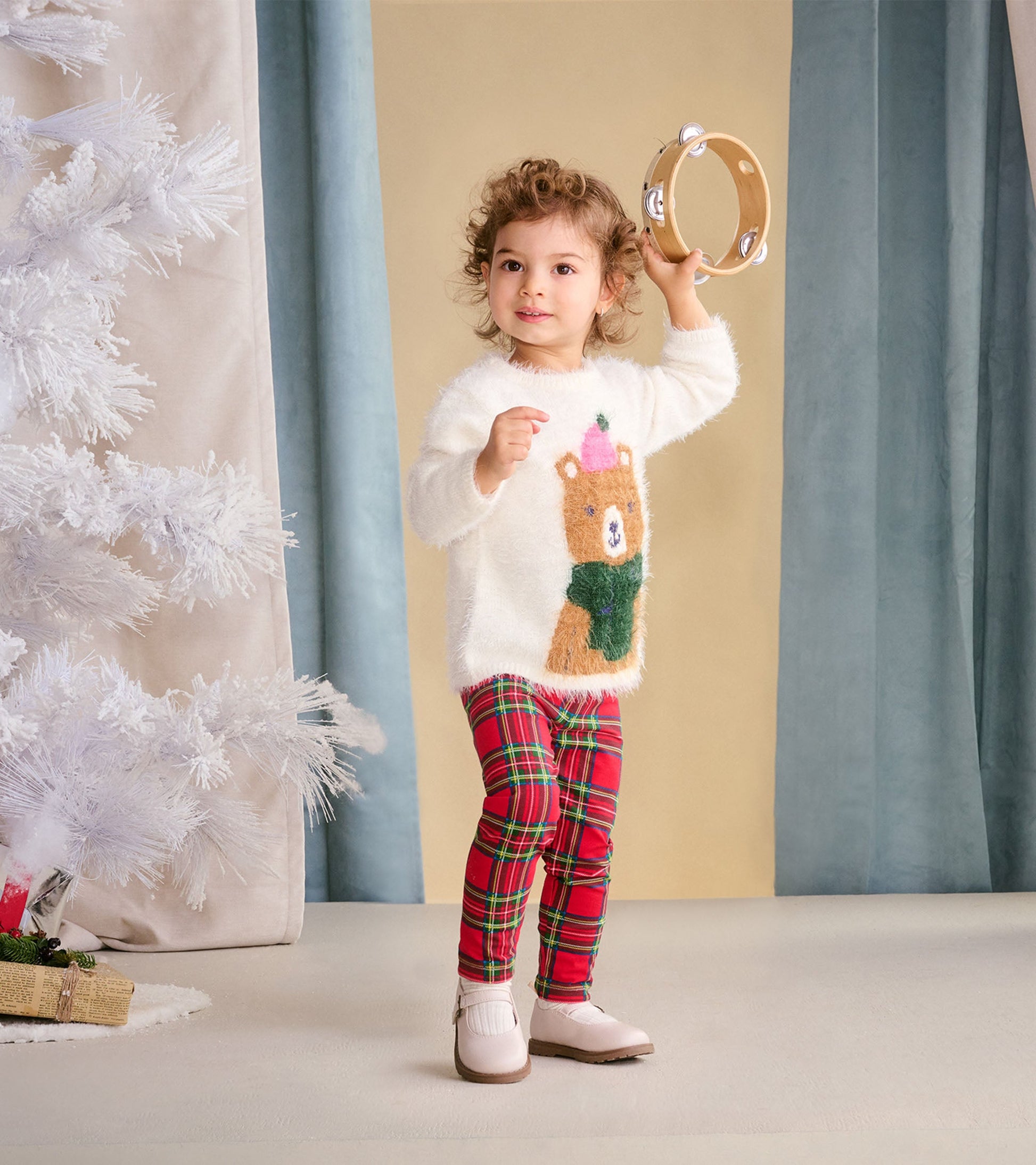 Red plaid leggings for babies and toddlers, featuring a snug fit and soft material, styled with a cozy white sweater.