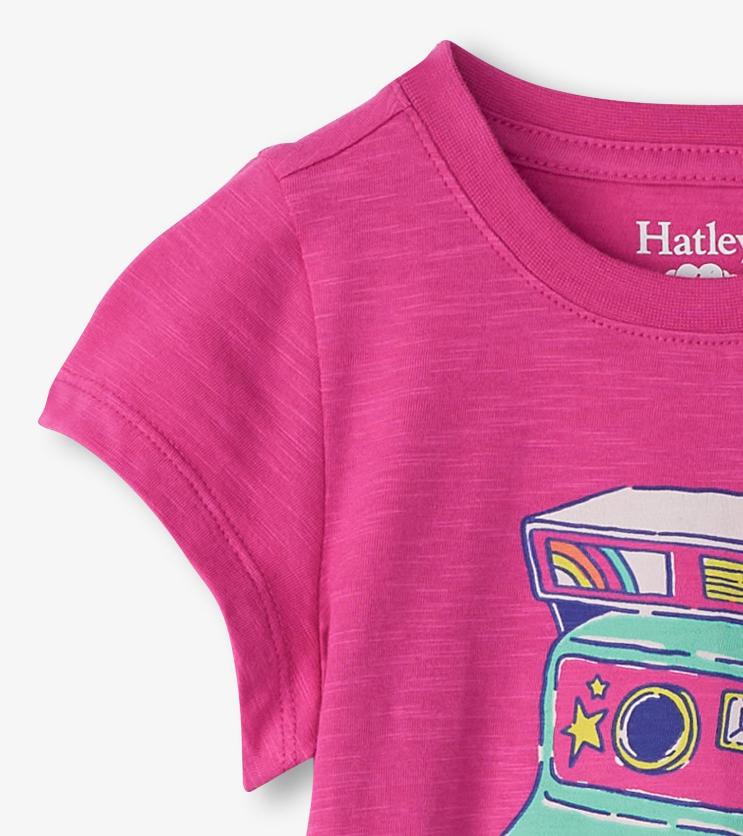 Bright pink short-sleeve tee featuring a colorful graphic of a vintage camera with stars and a rainbow design.