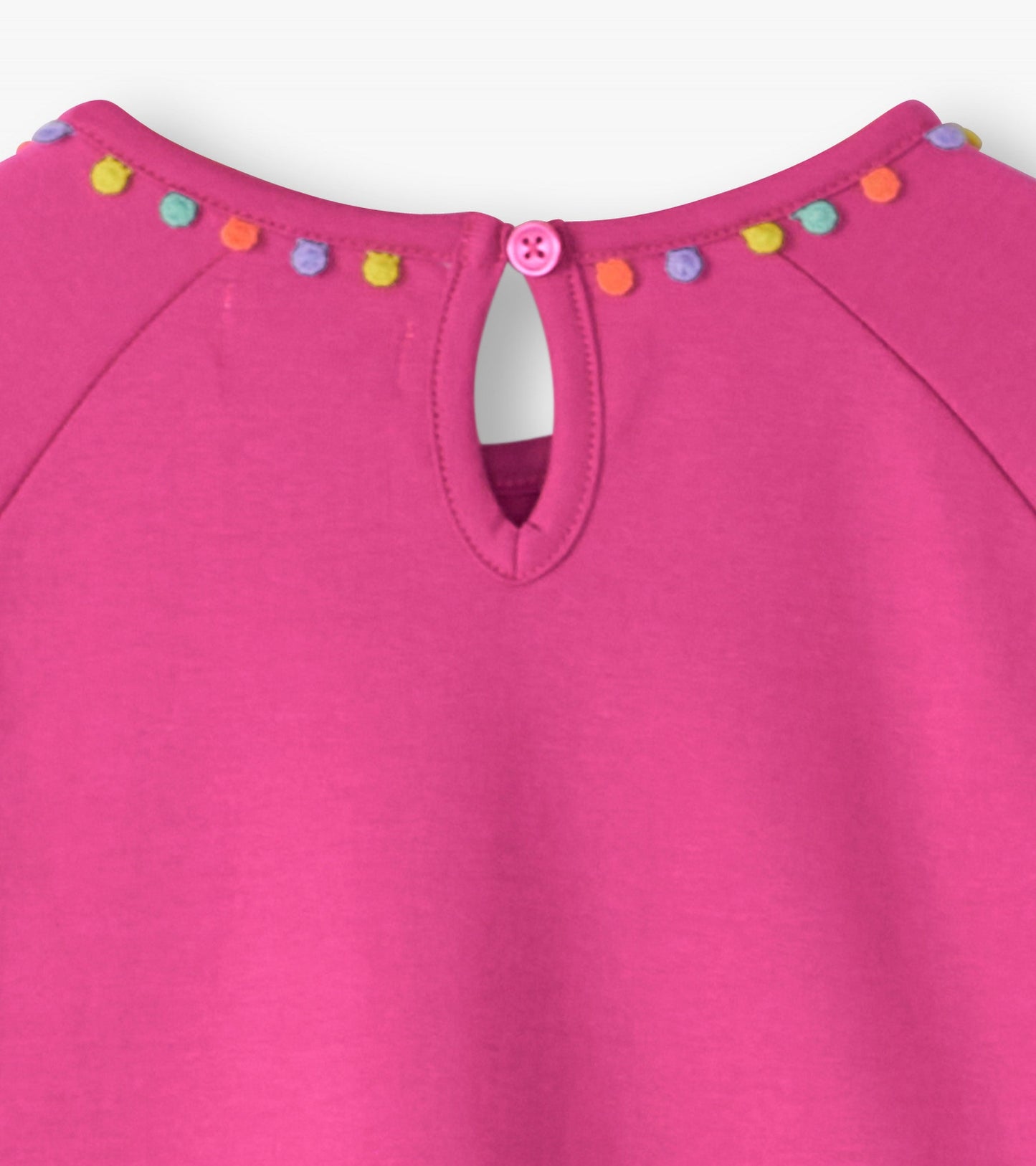 Pink gathered dress with colorful pom-pom trim and a keyhole back closure.