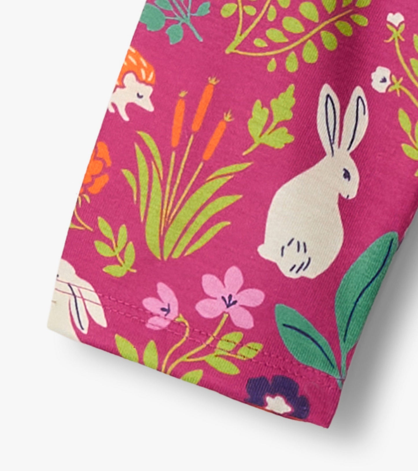 Pink nightgown featuring a playful pattern of bunnies, flowers, and greenery, made from soft, comfortable fabric.