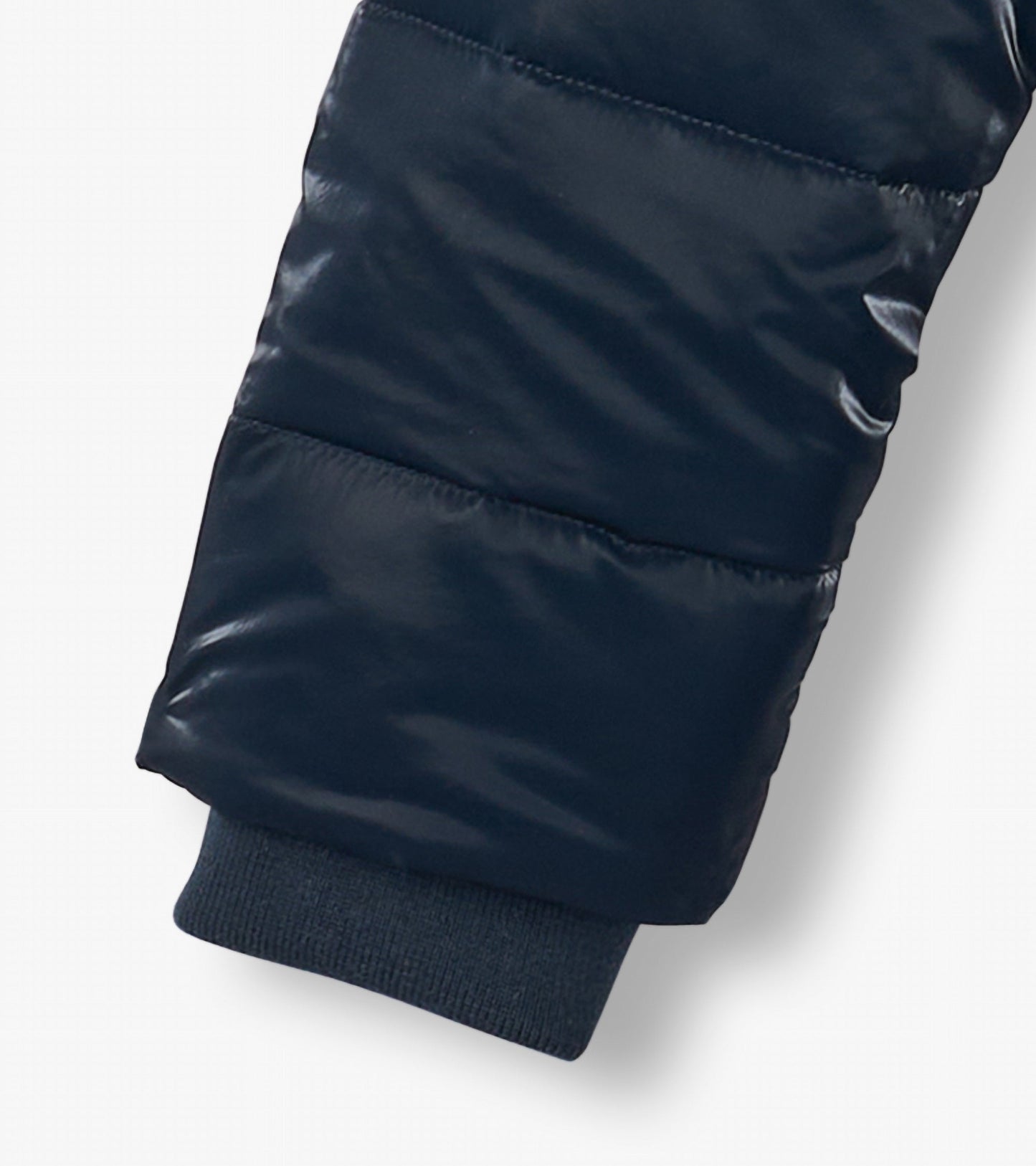 Navy blue puffer jacket sleeve with a shiny finish and ribbed cuff, designed for boys.
