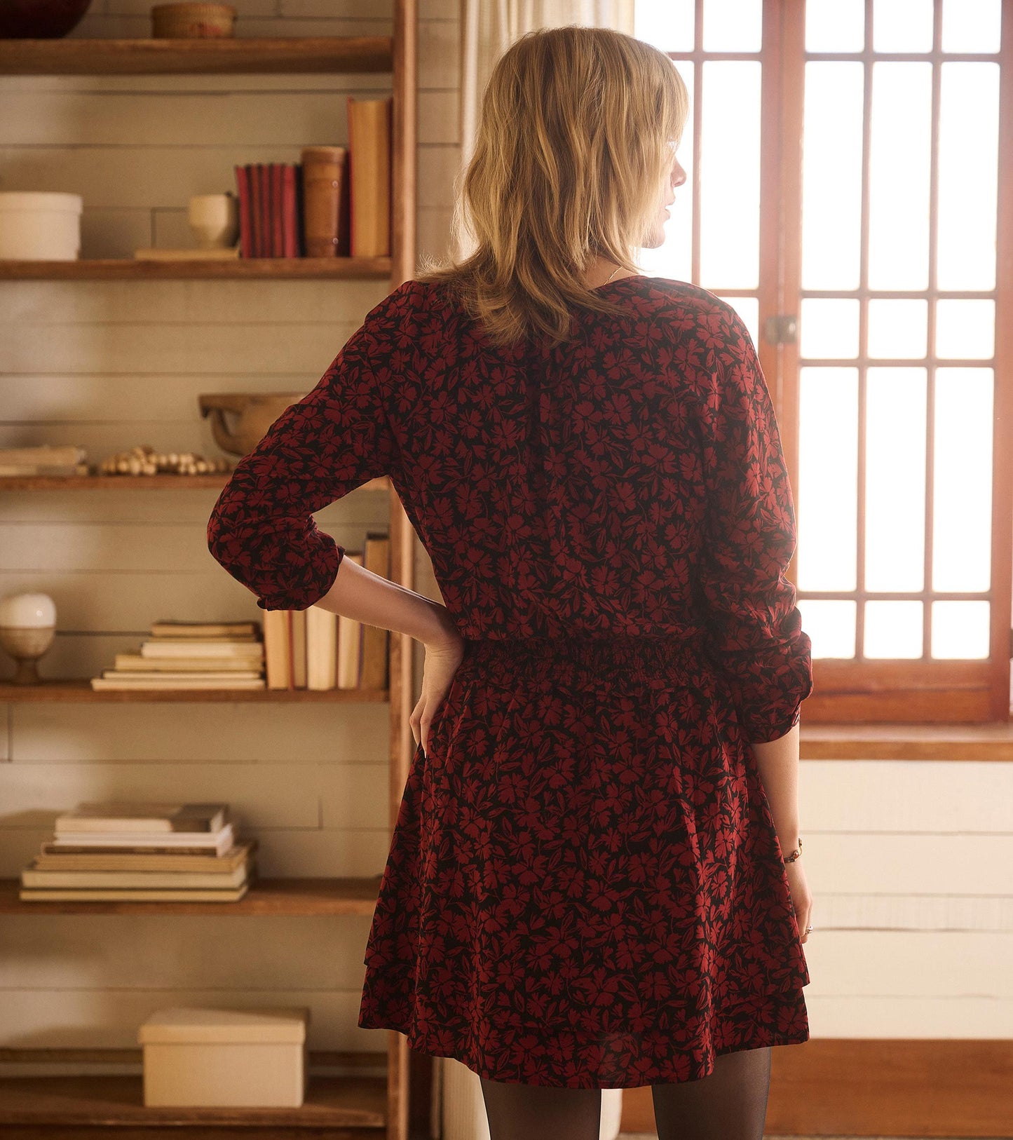 Floral scatter print dress with a smocked waist, long sleeves, and a flared skirt, viewed from the back.