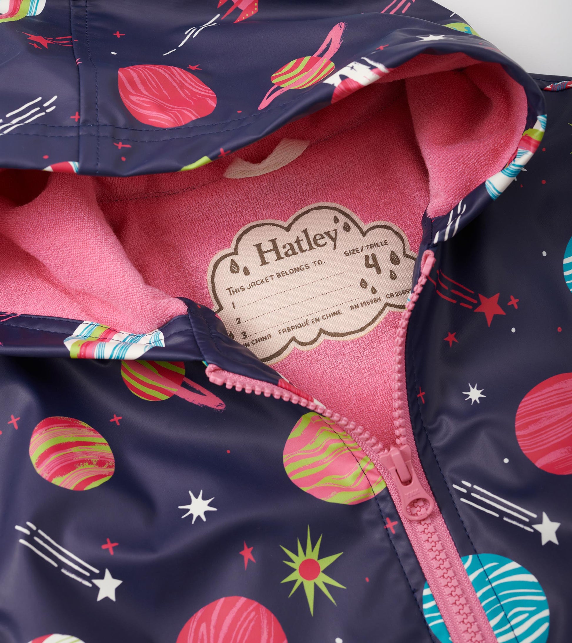 Navy zip-up rain jacket featuring colorful planet and star patterns, with a pink fleece lining inside the hood.